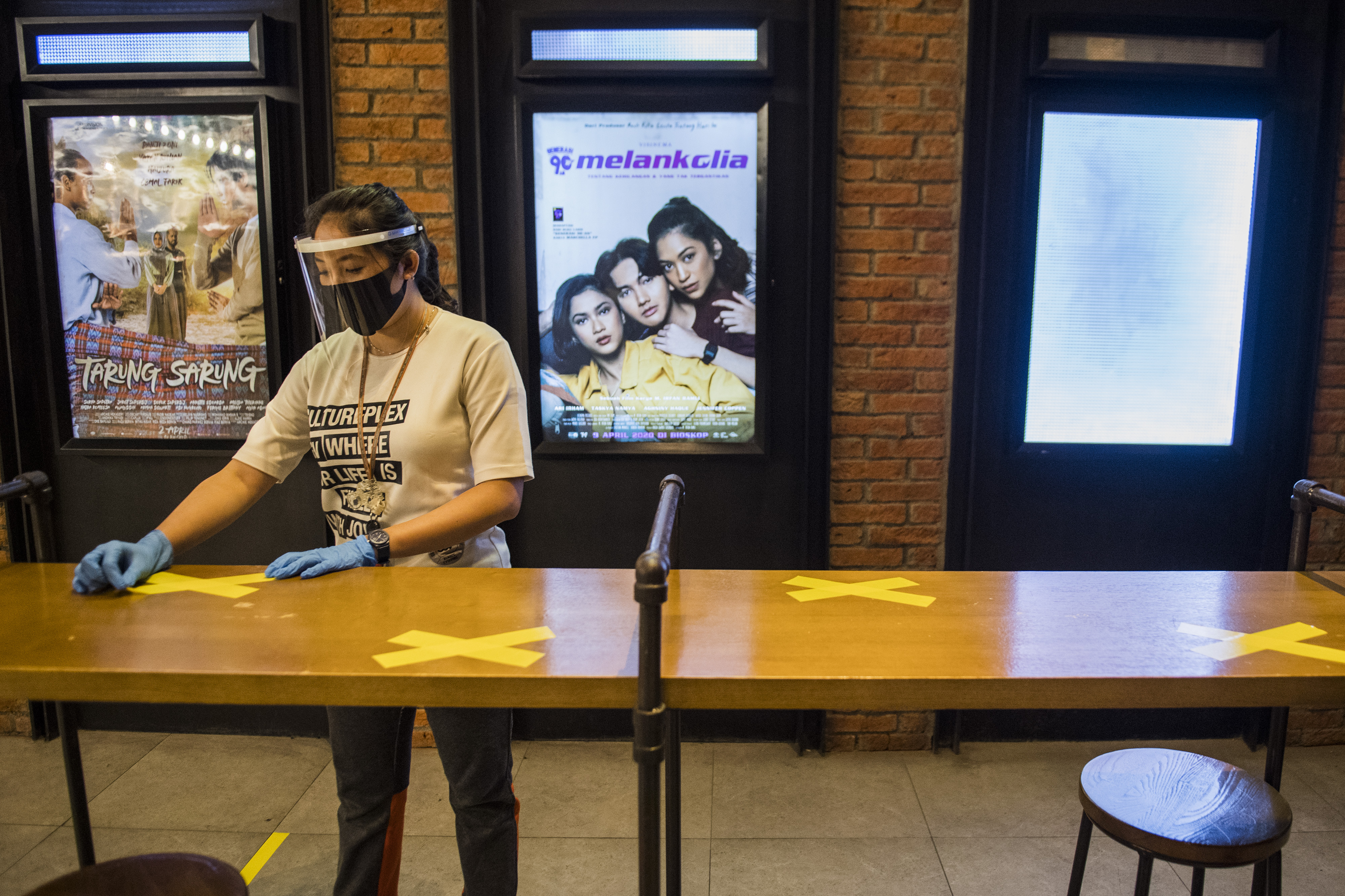 Pekerja memasang tanda saat simulasi pembukaan CGV Cinemas di Bandung Electronic Center (BEC), Bandung, Jawa Barat, Kamis (9/7/2020).