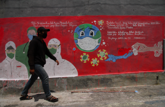 Seorang warga melintas di depan mural kampanye untuk melawan covid-19 di kawasan Depok, Jawa Barat, Kamis (27/8/2020). 