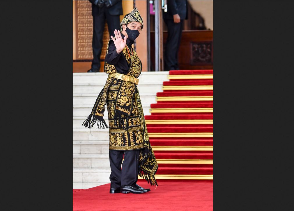 Presiden Joko Widodo melambaikan tangan ke arah wartawan saat tiba di lokasi sidang tahunan MPR di Komplek Parlemen.