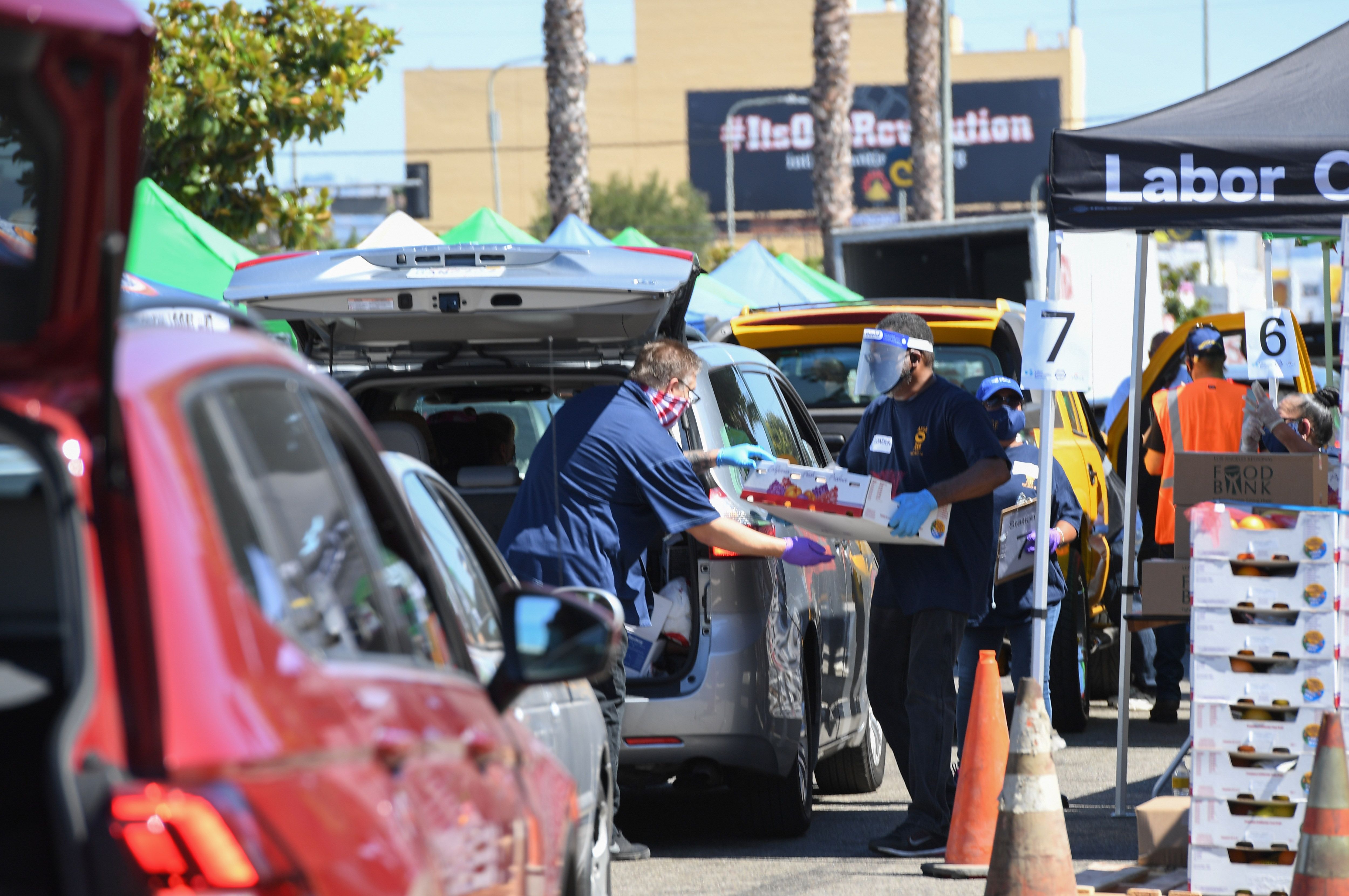 Relawan memasukkan sumbangan makanan untuk warga yang terpengaruh covid-19 di Los Angeles, California.