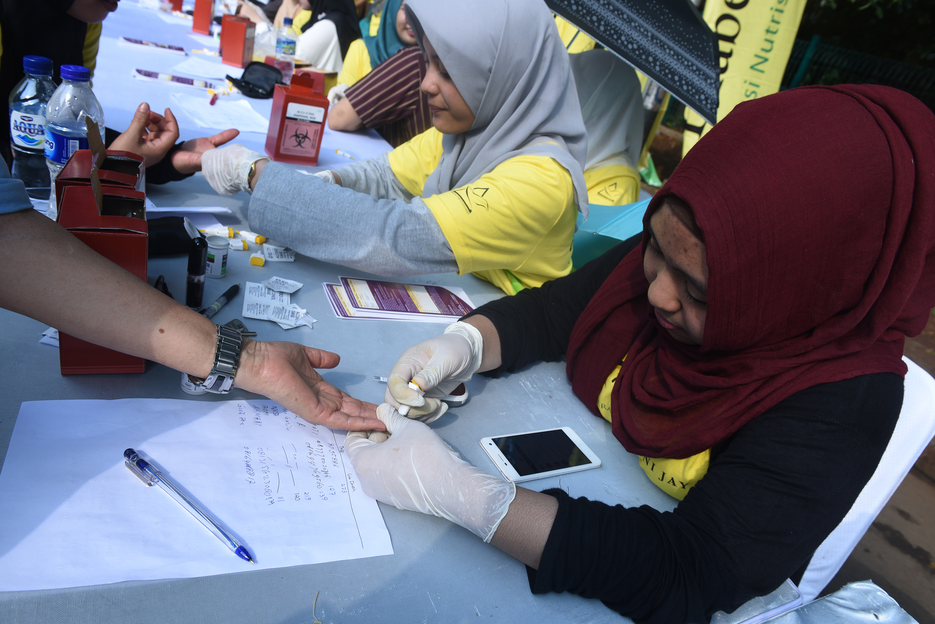 Mahasiswa Fakultas Kedokteran UI memeriksa gula darah warga secara cuma-cuma saat acara Jakarta Diabetes 