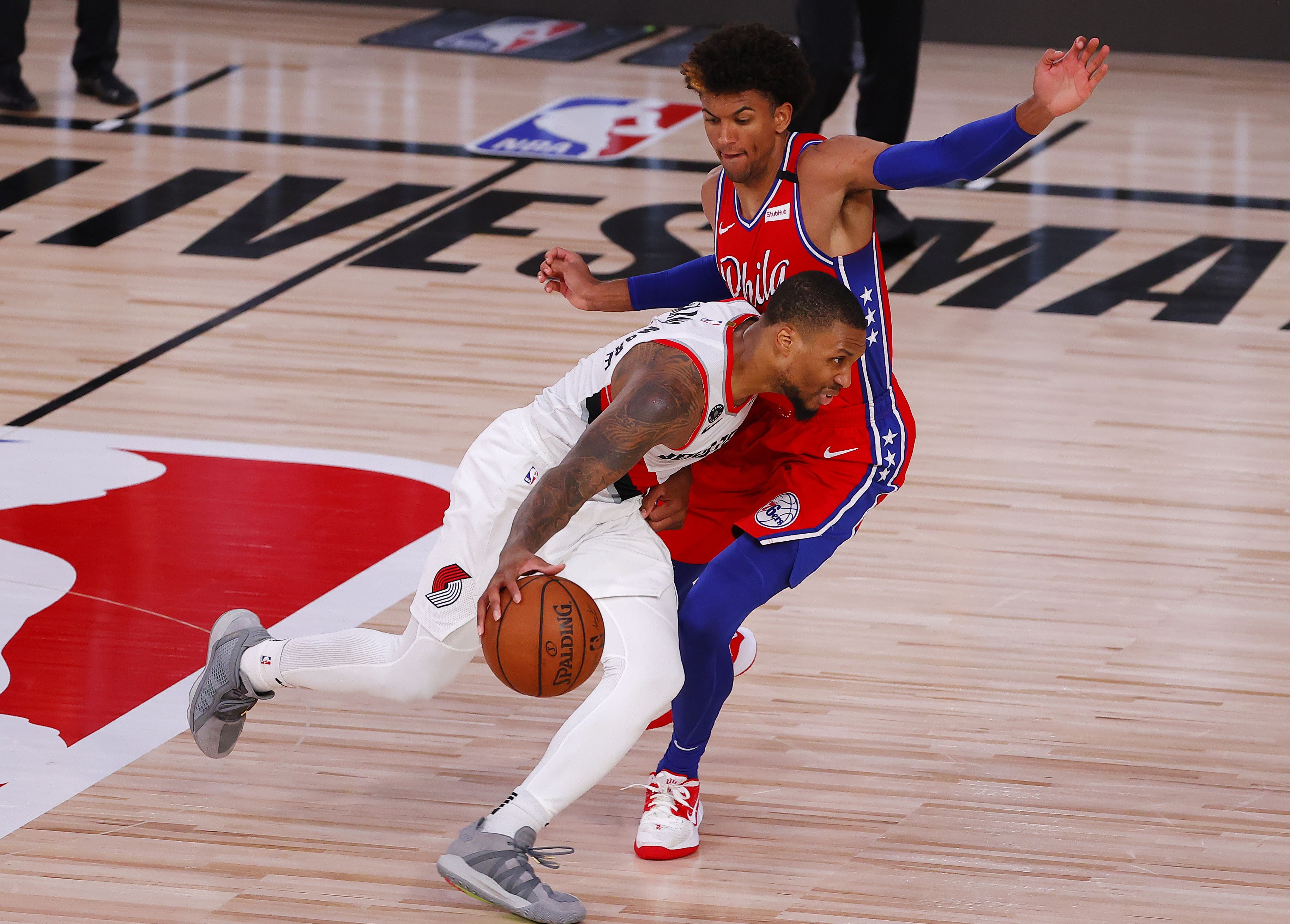 Pemain Portland Trail Blazers Damian Lillard berusaha melewati penjgaan pemain Philadelphia 76ers Matisse Thybulle dalam laga lanjutan NBA.