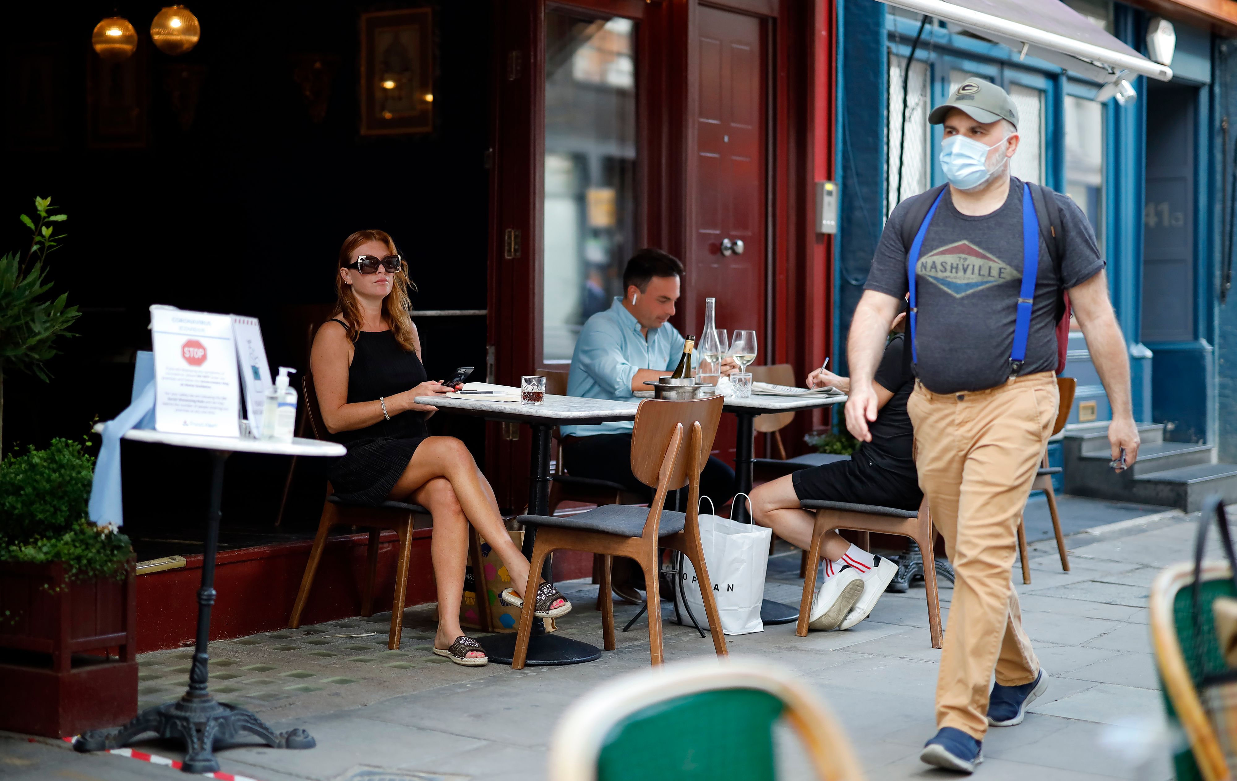 Sejumlah warga duduk di depan restoran di Manchester, Inggris.