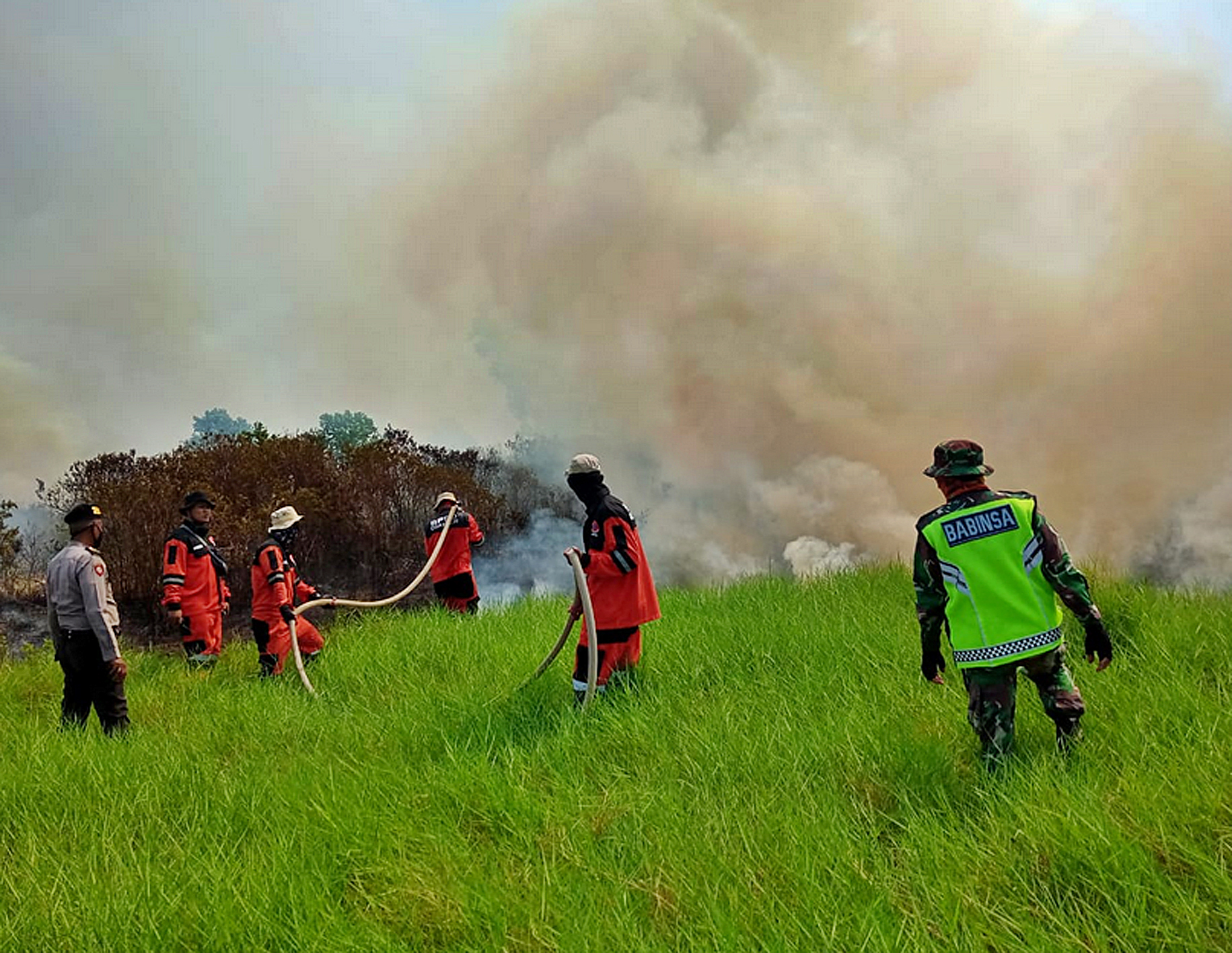 KARHUTLA : Petugas gabungan personel BPBD, TNI, dan Polri berusaha memadamkan kebakaran lahan di tepi Tol Palembang-Indralaya, Ogan Ilir