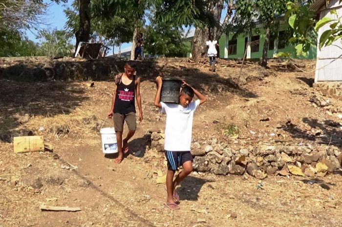 Warga mencari air setelah pasokan PDAM mulai berkurang akibat keringnya beberapa sumber air baku.  