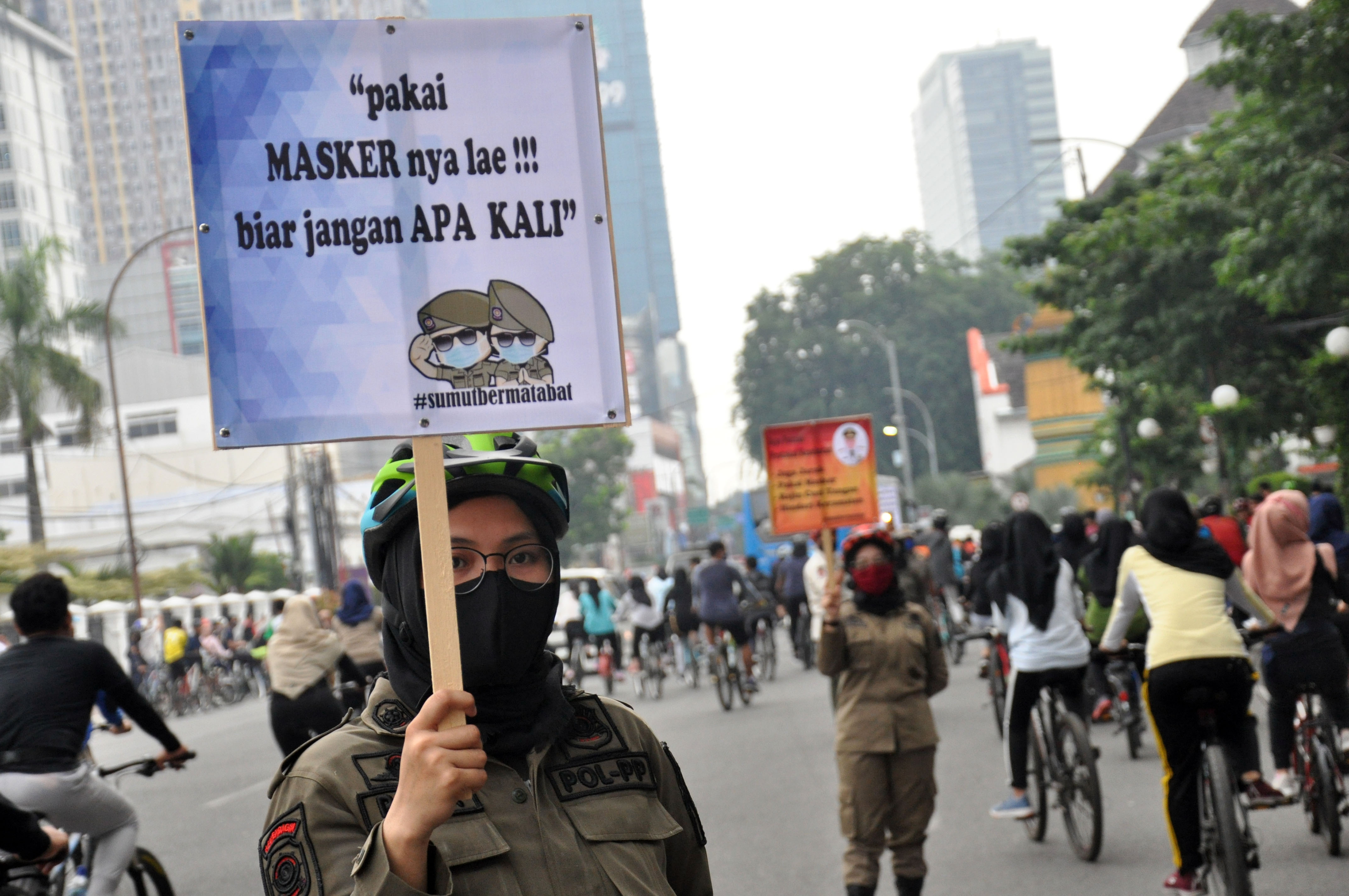 Petugas Satpol PP memberikan imbauan protokol kesehatan bagi warga yang berolah raga di kawasan Lapangan Merdeka Medan, Sumatera Utara.
