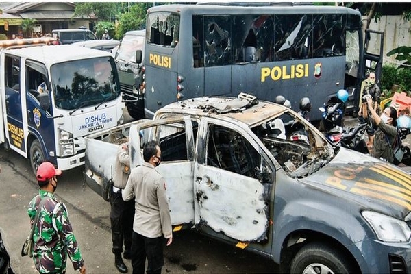 Petugas memeriksa mobil operasional yang dibakar dan bus yang dihancurkan kacanya saat olah TKP di Polsek Ciracas, Jakarta Timur, kemarin.