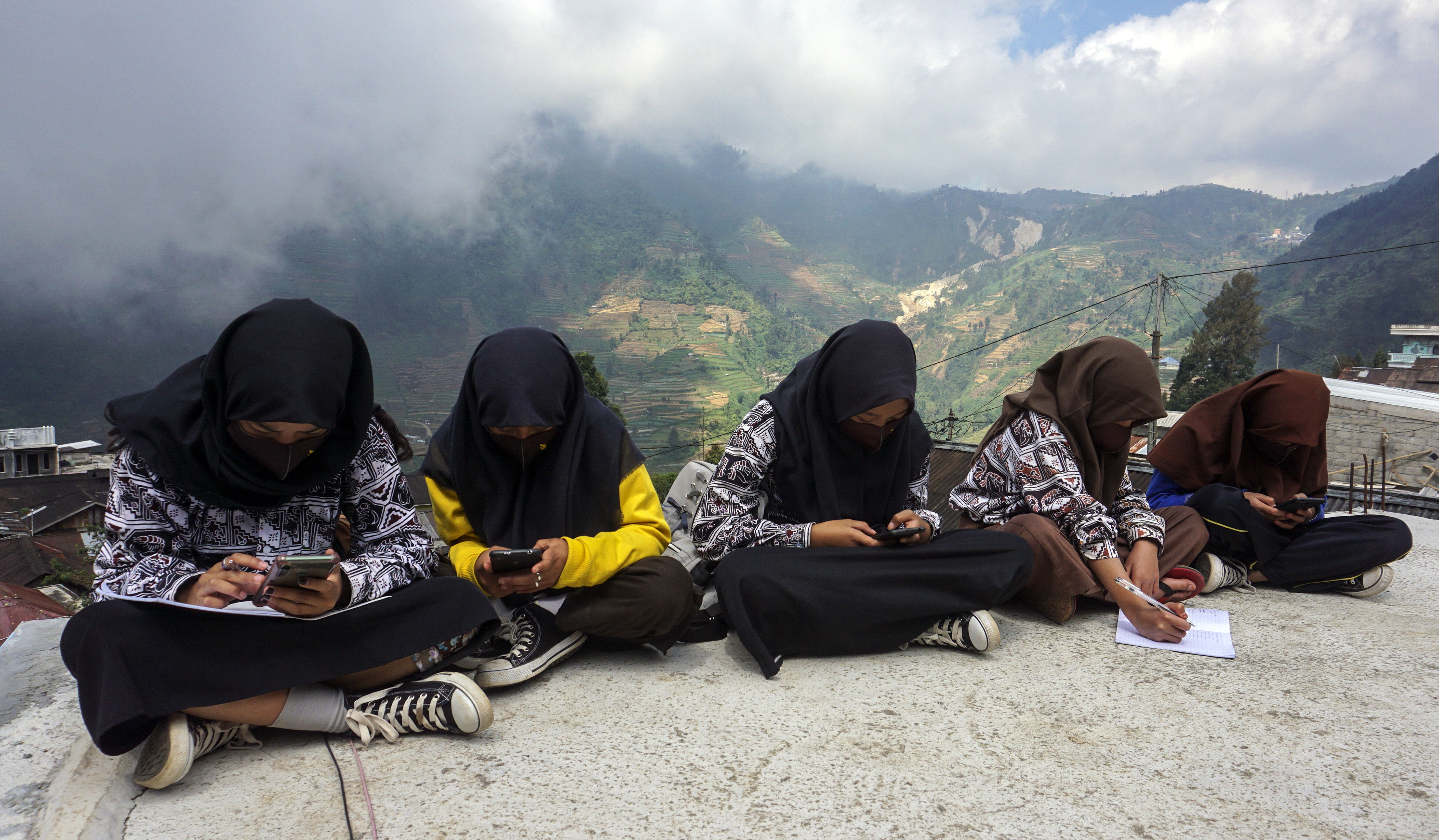 Pelajar SMPN 4 Bawang berada di atas bangunan kamar mandi umum untuk mendapatkan sinyal gratis di Sigemplong, Bawang, Batang, Kamis (30/7).