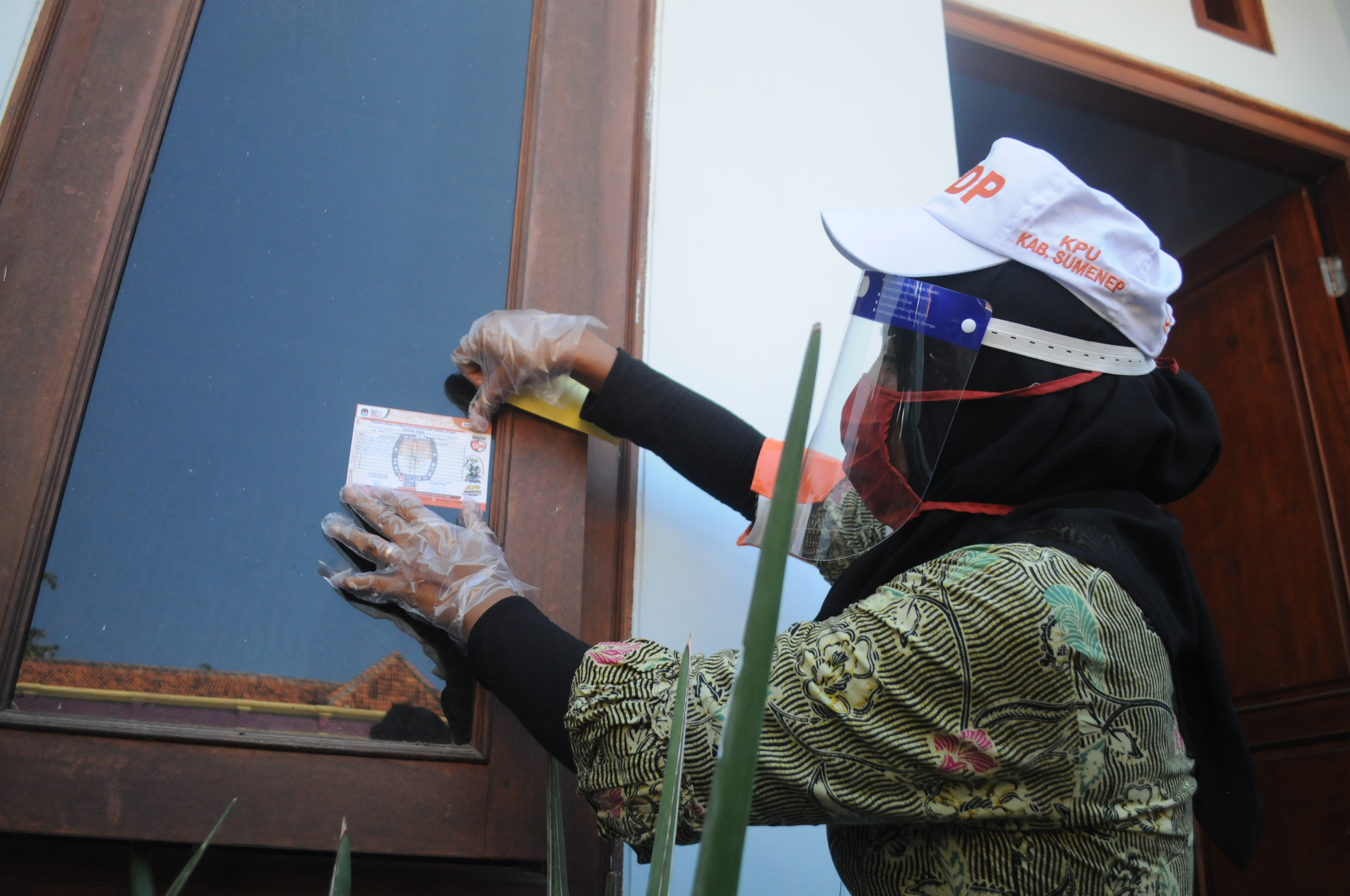 Petugas Pemutakhiran Data Pemilih (PPDP) menempelkan stiker saat Pencocokan dan Penelitian (Coklit) serentak.