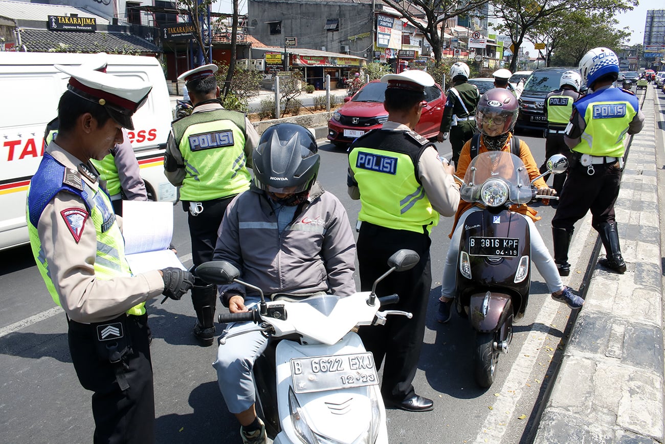 Polisi menilang pengendara motor yang menerobos jalur cepat saat menggelar Operasi Patuh Jaya 2019 di Jalan Margonda, Depok, Jawa Barat.
