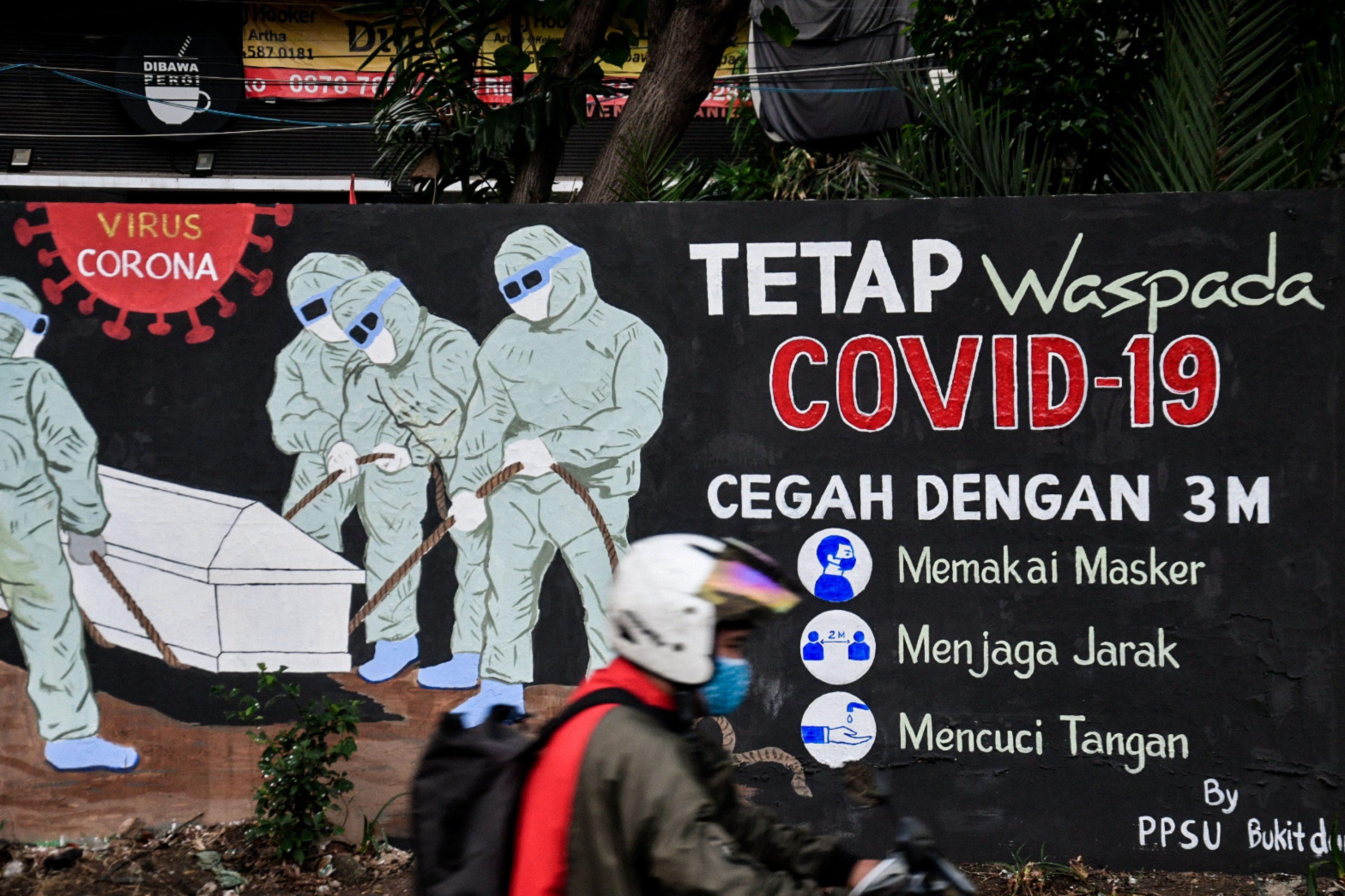 Pengendara melintas di depan mural bertema covid-19 di Tebet, Jakarta, Selasa (11/8).