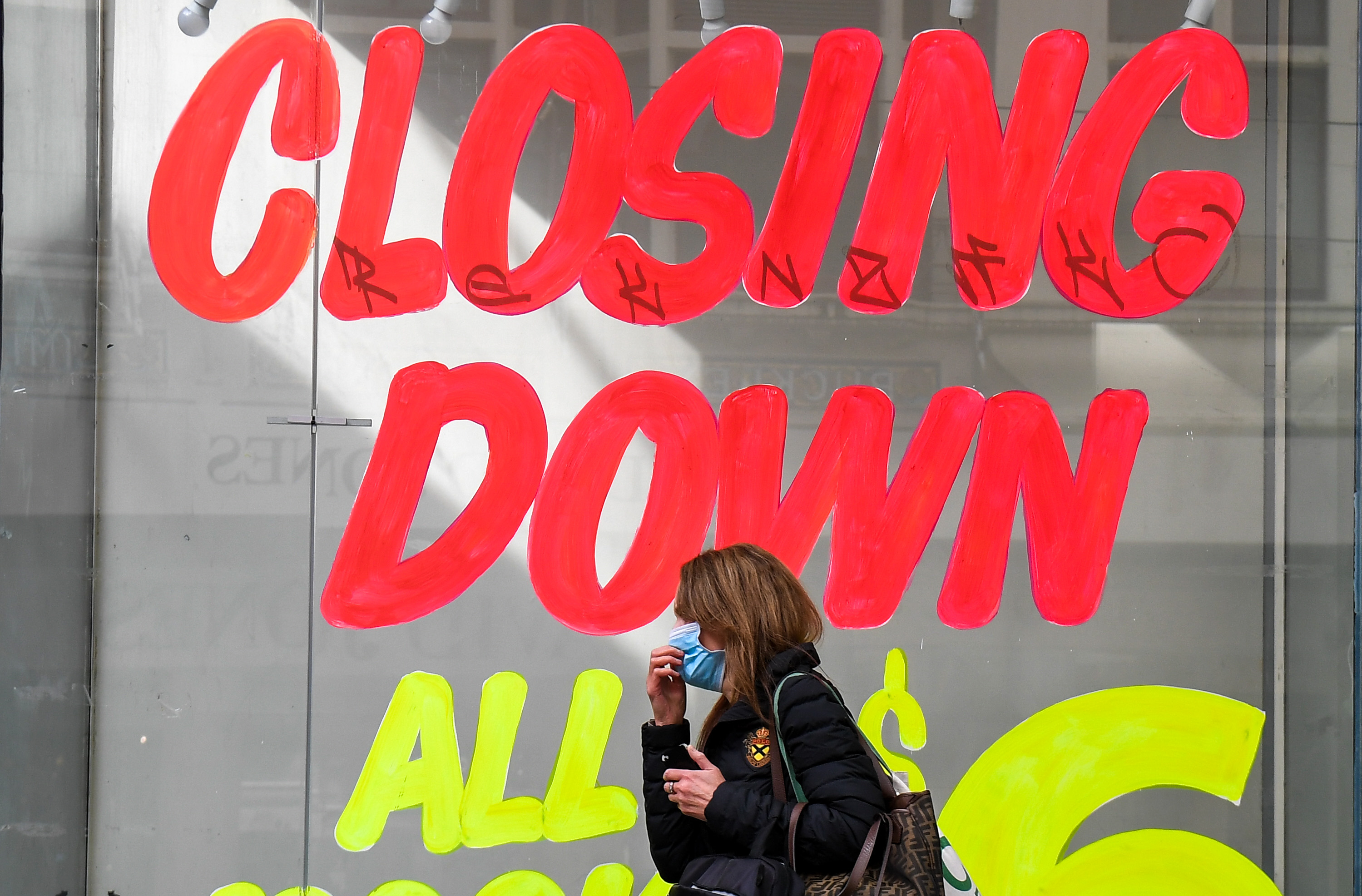  Seorang wanita berjalan melewati sebuah toko kosong di kawasan pusat bisnis Melbourne, Australia, Senin (3/8).