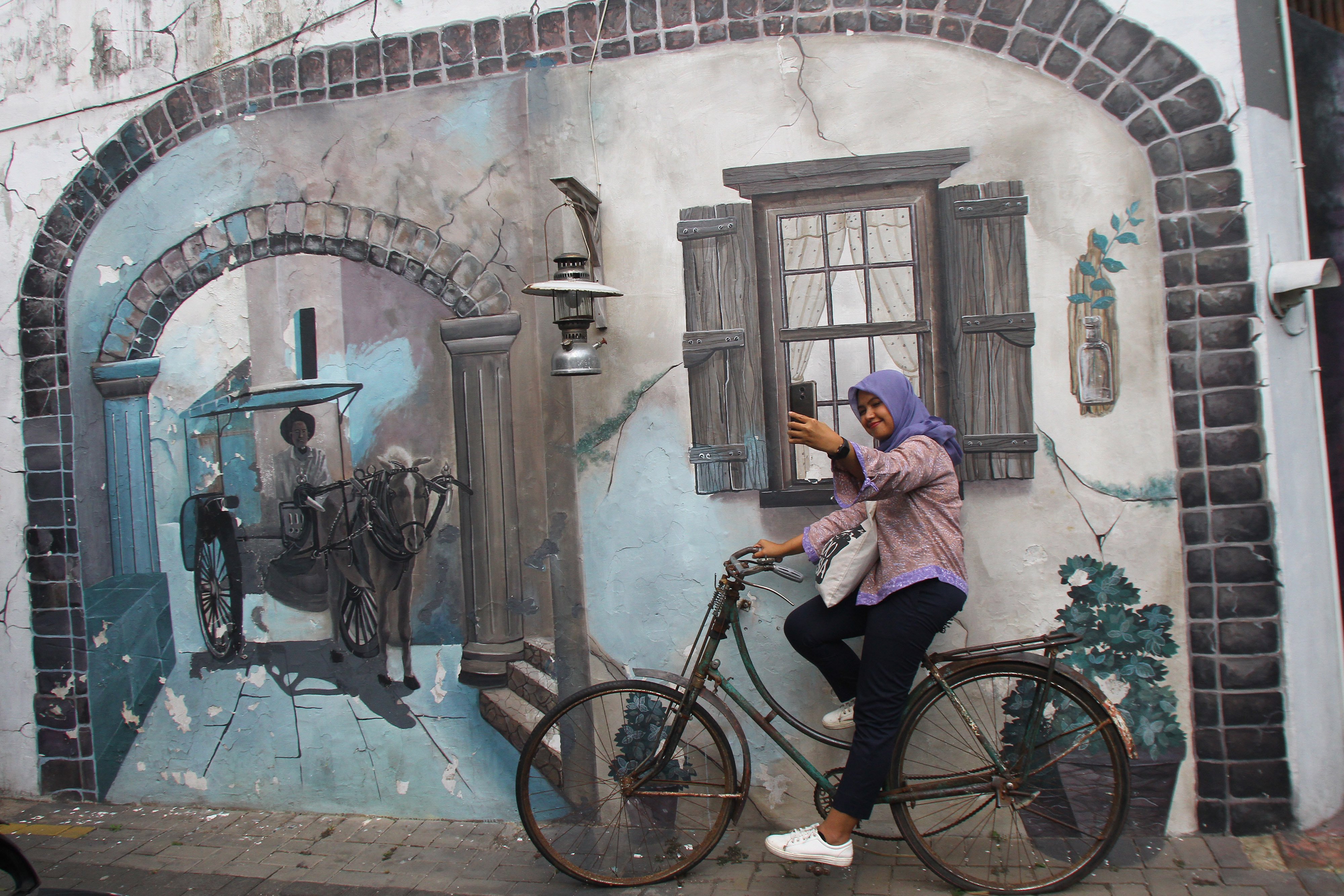 Pengunjung melakukan swafoto di salah satu sudut Kampung Wisata Heritage, Kayutangan, Malang, Jawa Timur, Kamis (7/11/2019)