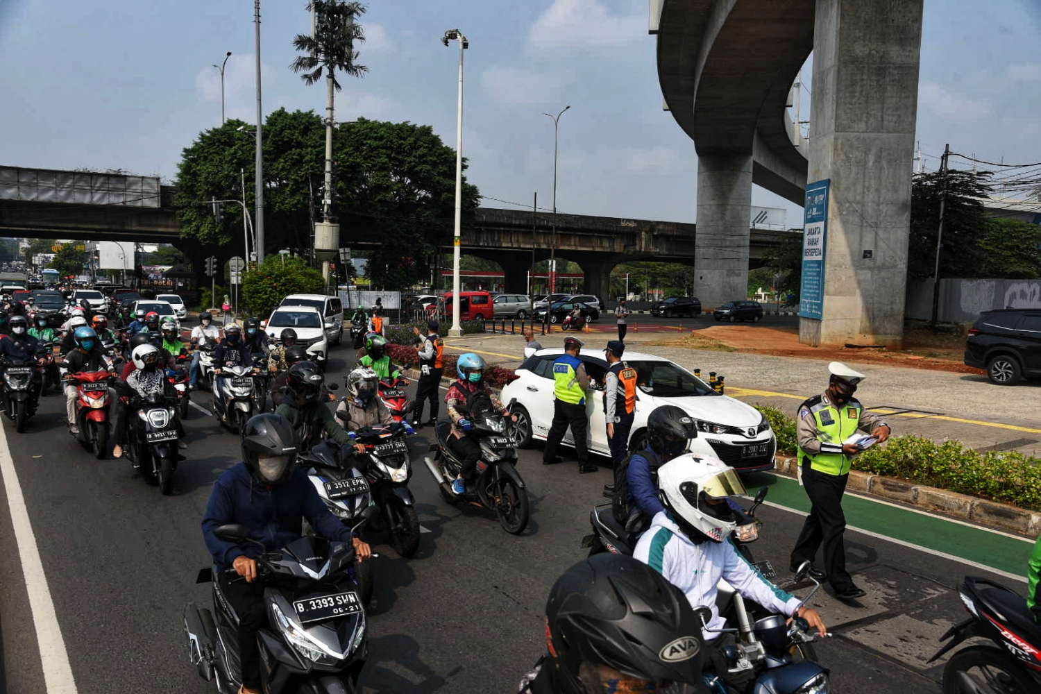 Anggota kepolisian menghentikan kendaraan di kawasan Fatmawati, Jakarta Selatan, Senin (10/8).