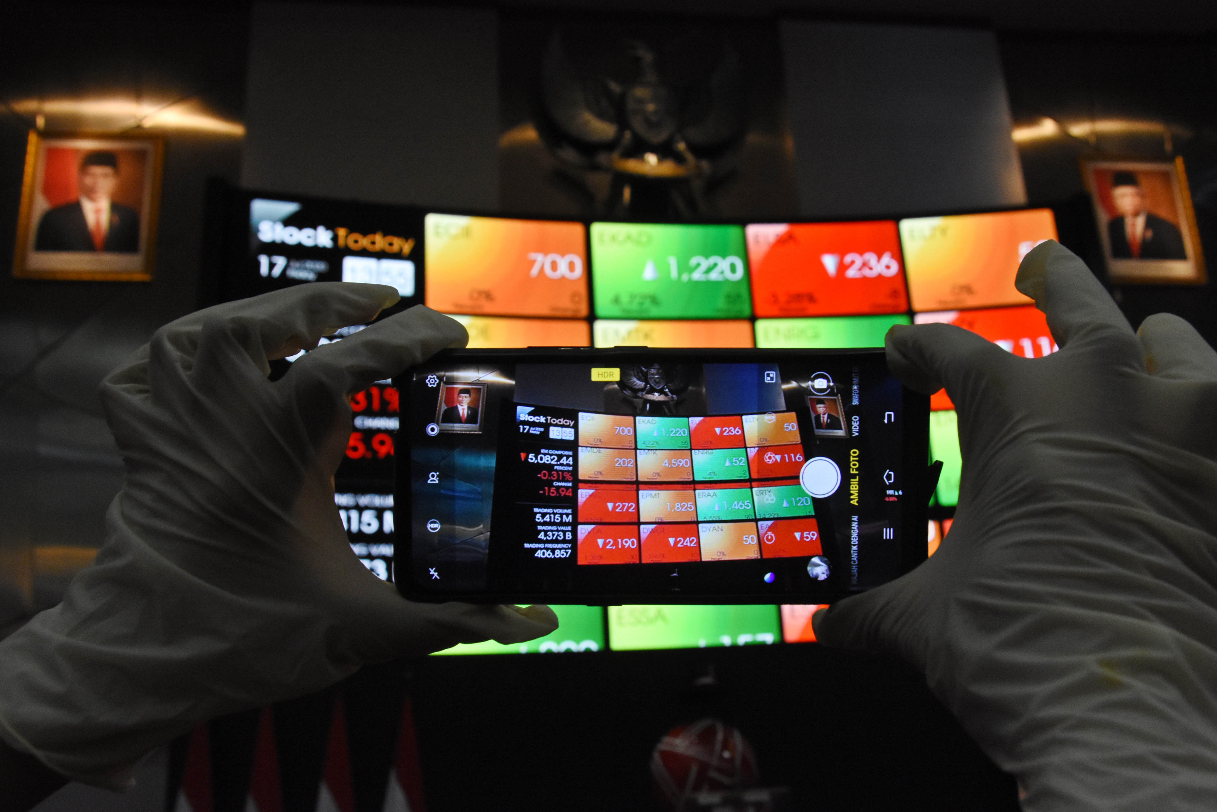  Karyawan mengambil gambar layar pergerakan harga saham di gedung Bursa Efek Indonesia, Jakarta