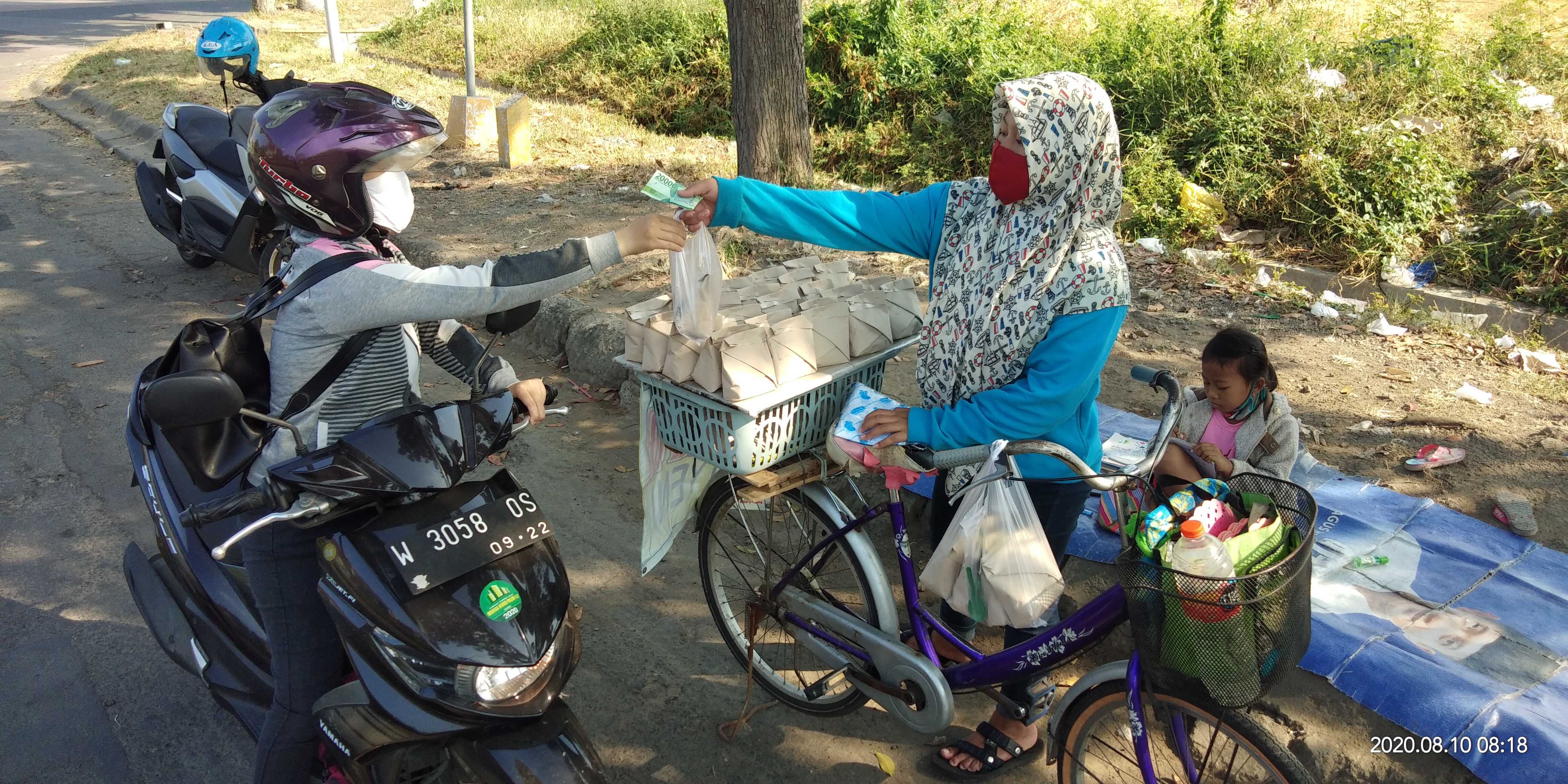 Sovi ditemani adiknya berjualan nasi bungkus di pinggir jalan Perumahan Deltasari Kecamatan Waru, Kabupaten Sidoarjo, Jawa Timur.