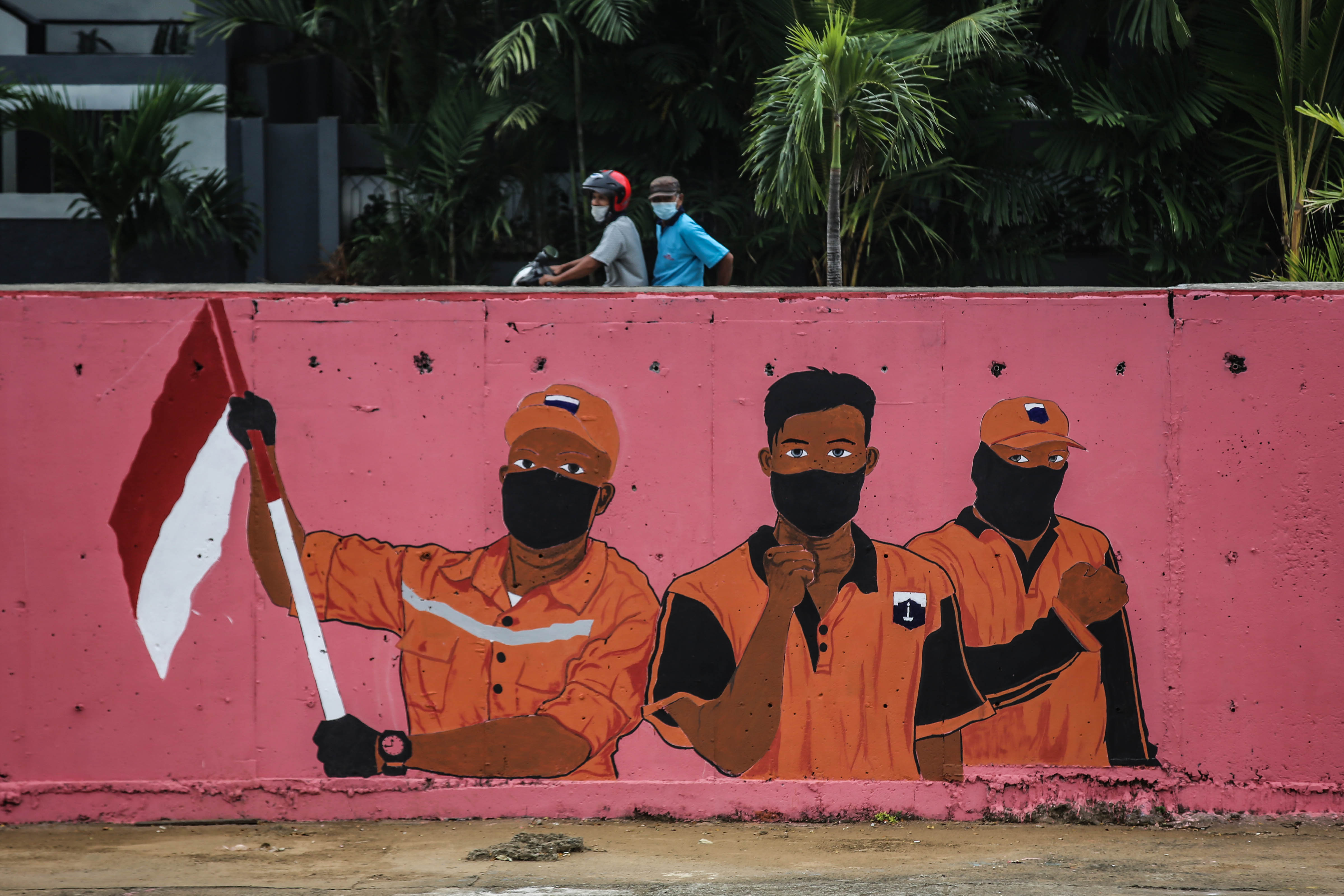 Warga melintas di dekat mural bergambar petugas PPSU di kawasan Kampung Melayu, Jakarta, Rabu (5/8).