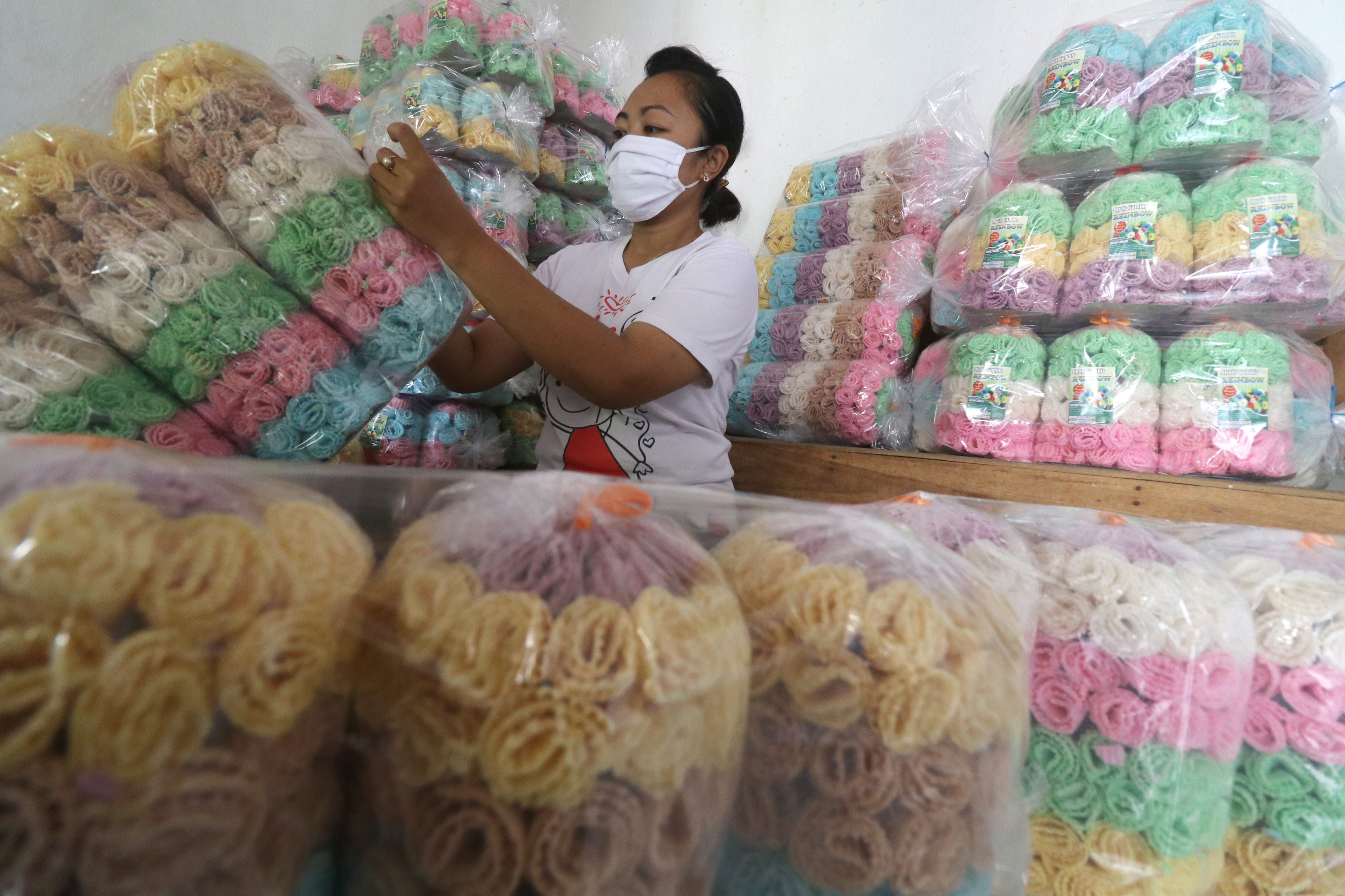 Pekerja sedang mengemas opak dalam plastik