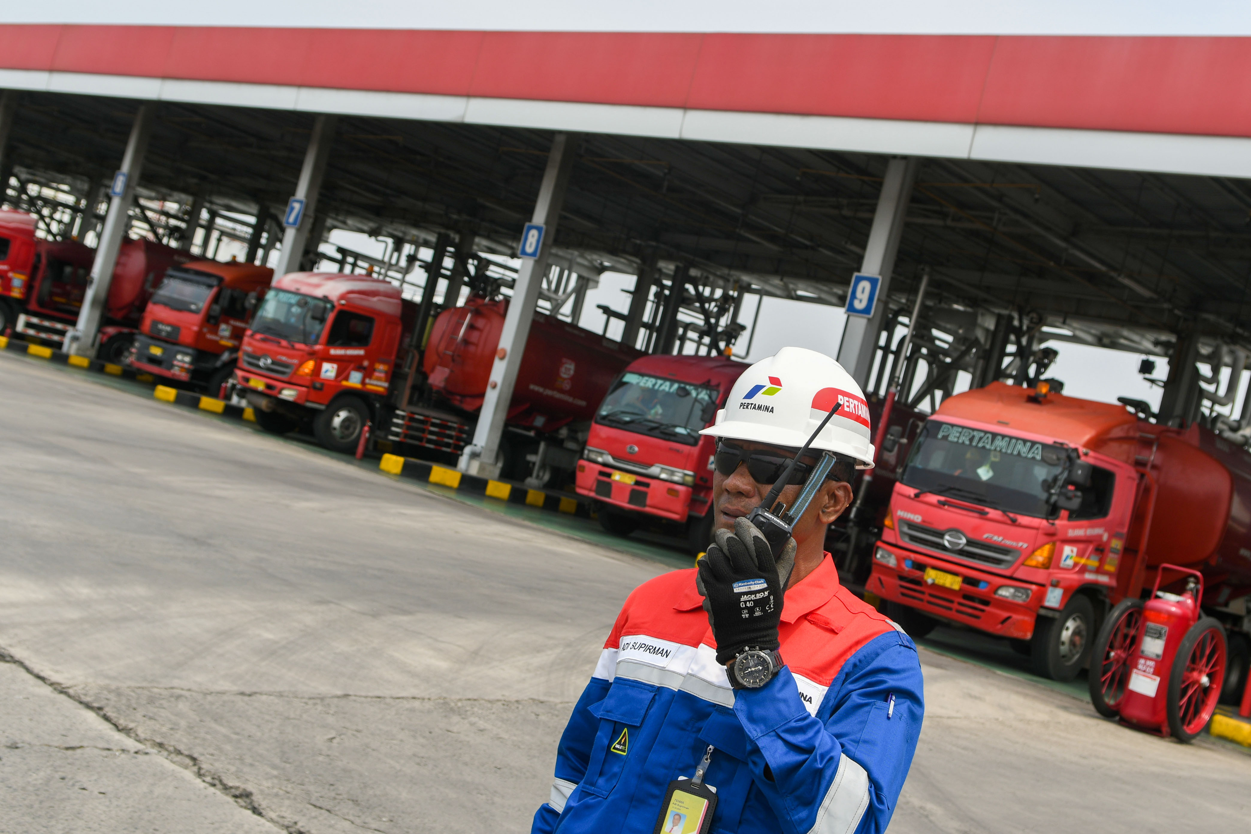 Seorang petugas berada di depan mobil tangki yang melakukan pengisian BBM ke mobil tangki di area pengisian otomatis (New Gantry System).