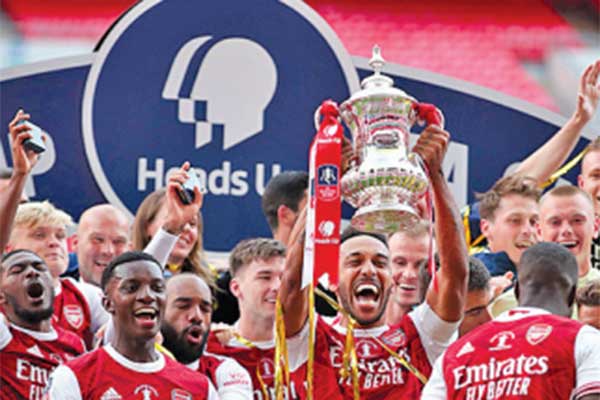Striker Arsenal asal Gabon Pierre-Emerick Aubameyang (tengah) memegang trofi juara 