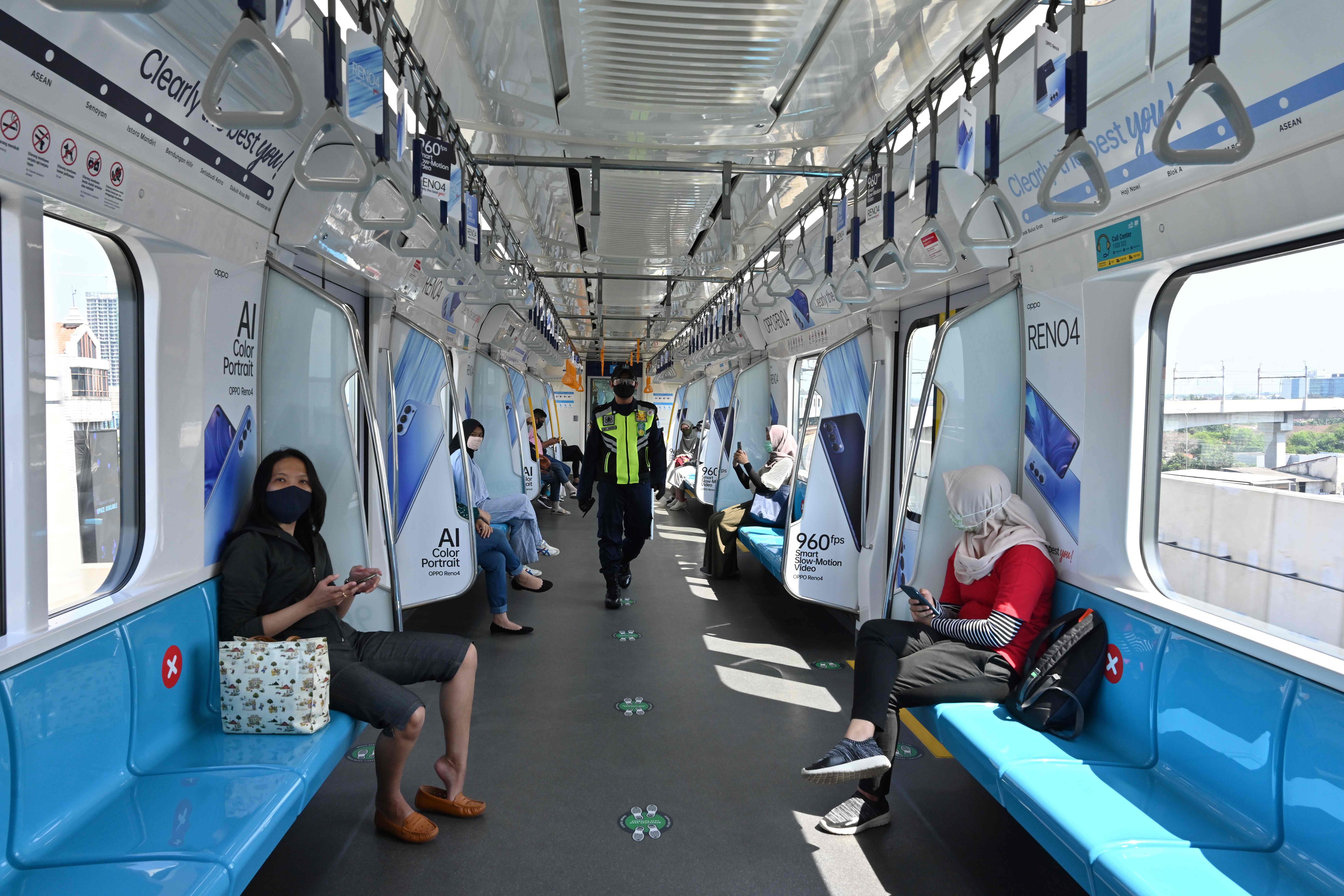 Penumpang duduk dengan menjaga jarak di dalam MRT Jakarta.