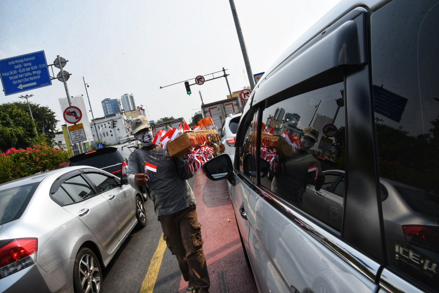 Seorang pedagang pernak-pernik berjualan di tengah lalu lintas kawasan Gunung Sahari, Jakarta Pusat.