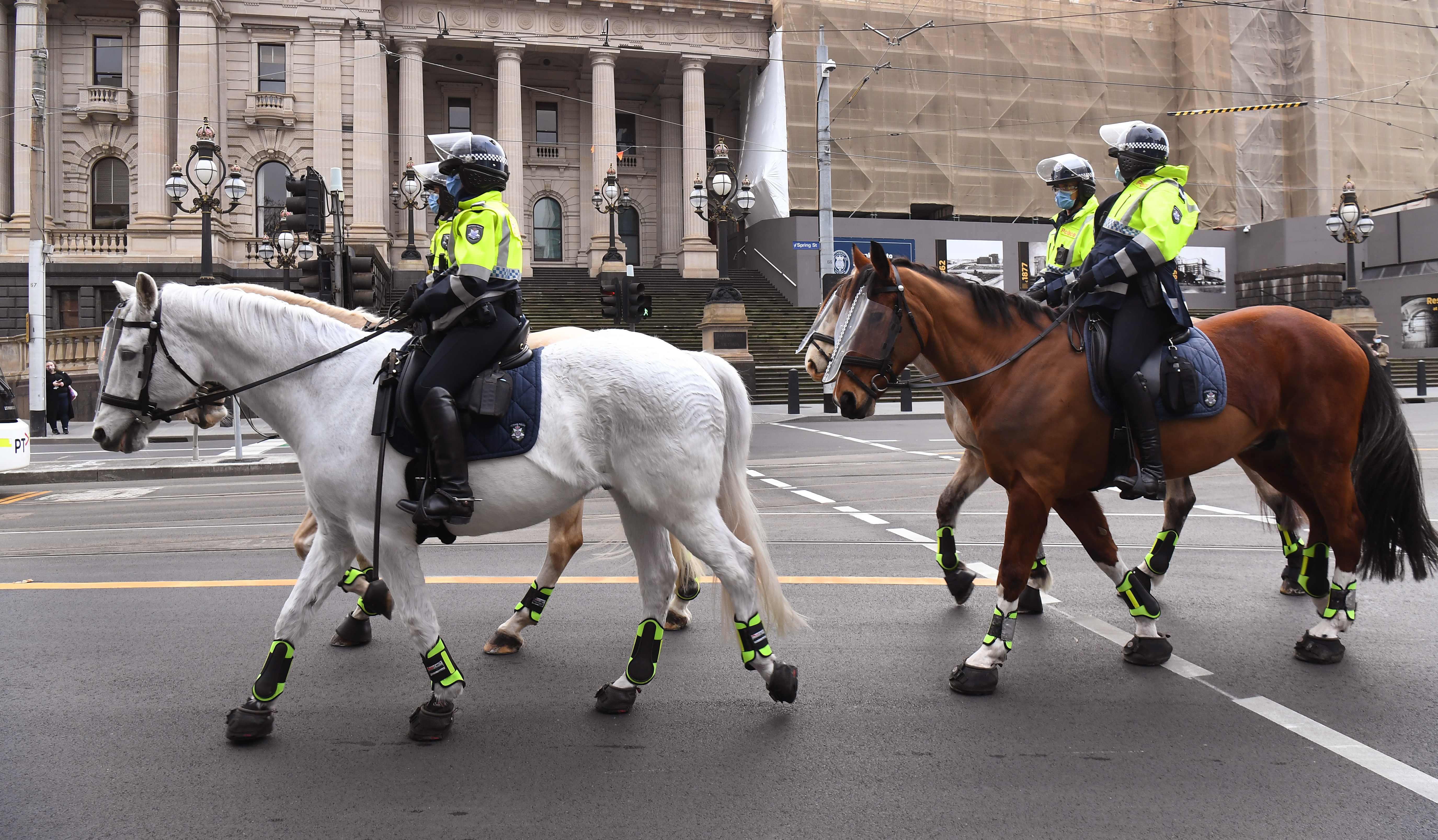 Polisi berkuda melakukan patroli di pusat bisnis di Melbourne pada 9 Agustus 2020