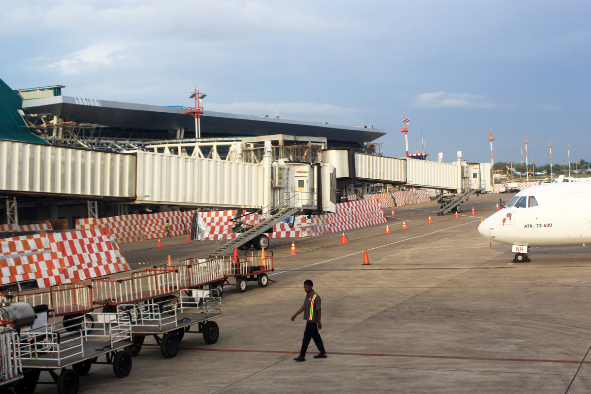 ilustrasi Seorang petugas melintas di dekat garbarata 