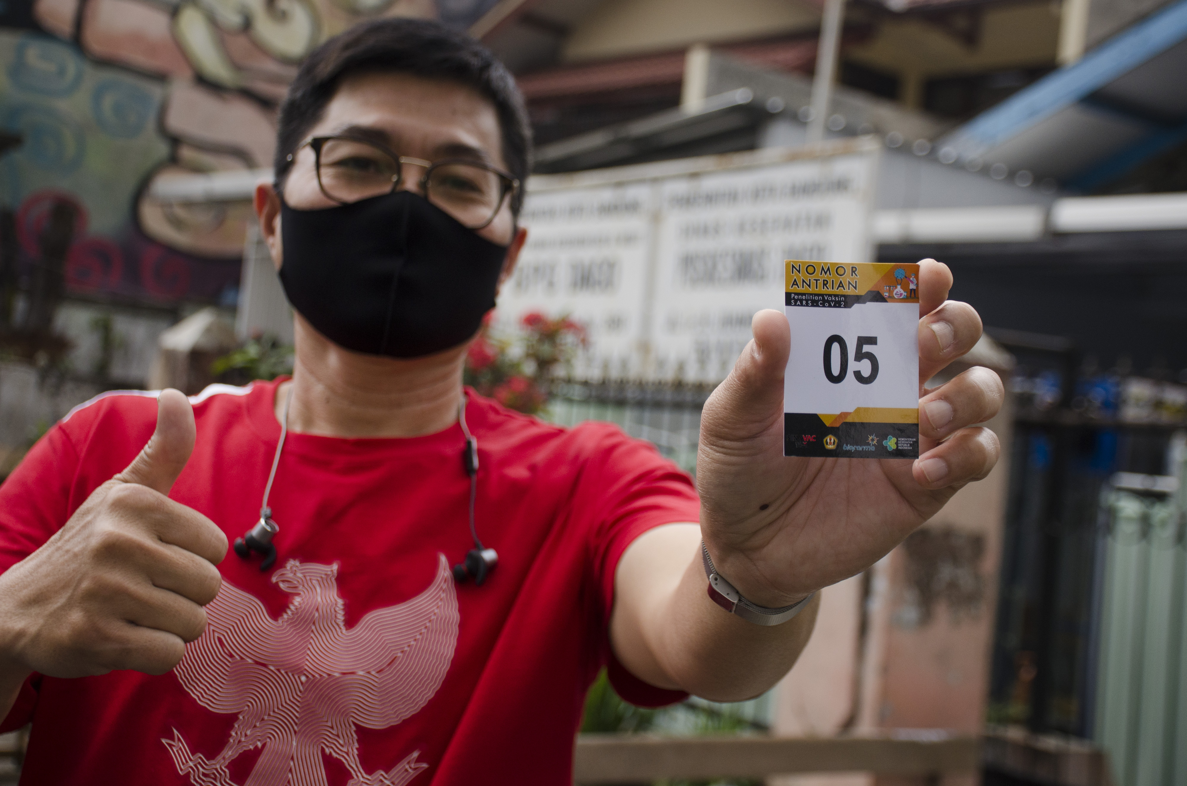 Seorang relawan menunjukkan nomor antrean uji klinis vaksin covid-19 di Puskesmas Dago, Bandung, Selasa (11/8/2020).