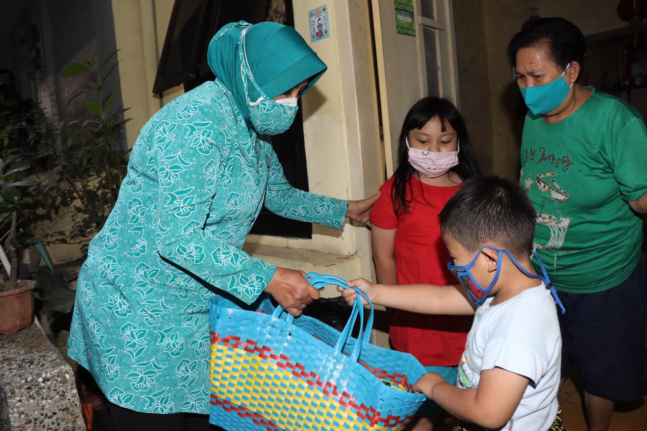Ketum TP PKK Pusat Tri Tito Karnavian (kiri) tengah membagikan masker pada sebuah keluarga di Malang, Jawa Timur.