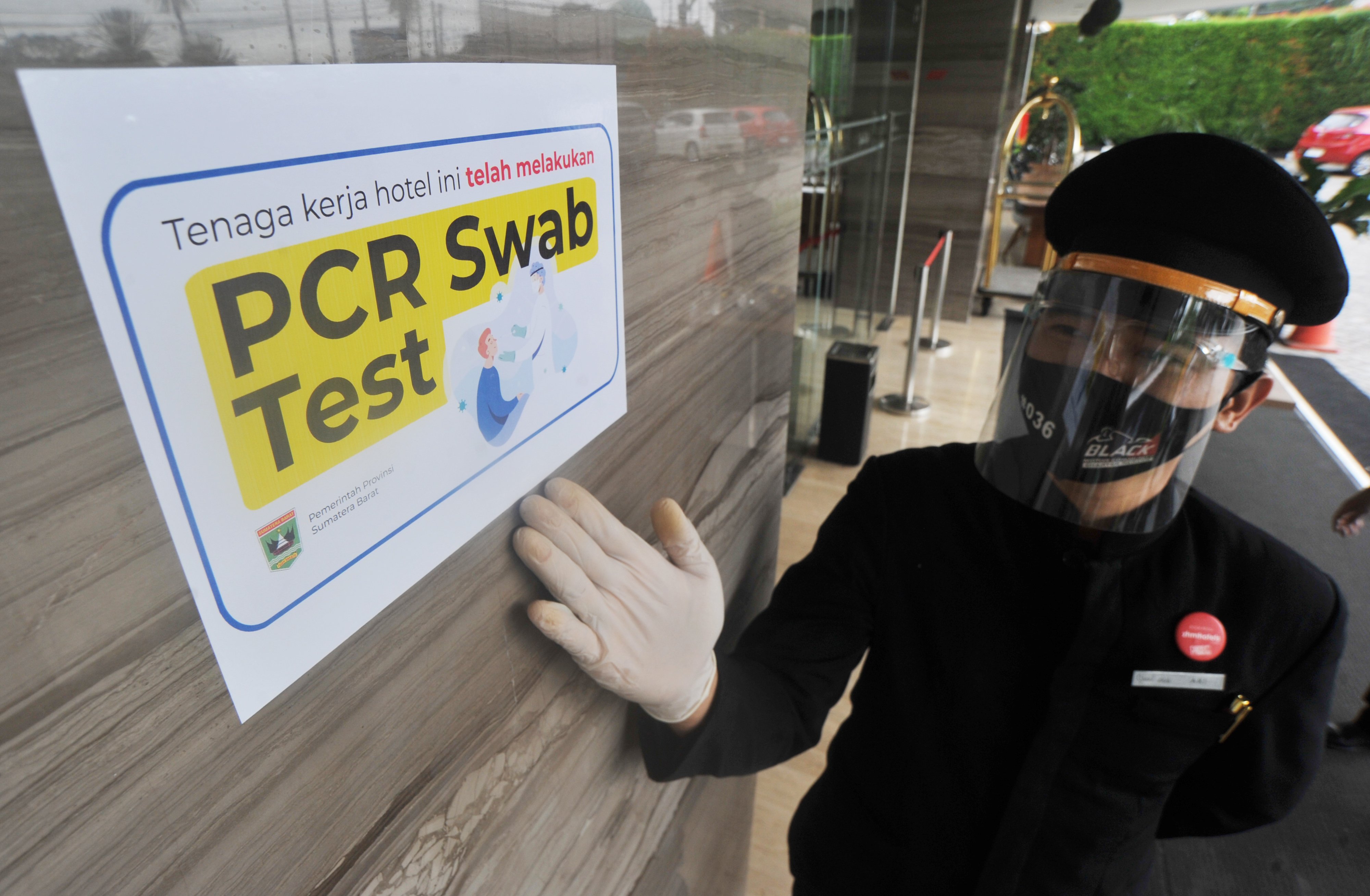 Seorang bellboy menunjukan stiker tanda bebas COVID-19, di hotel Grand Zuri Padang, Sumatera Barat, Rabu (1/7). 