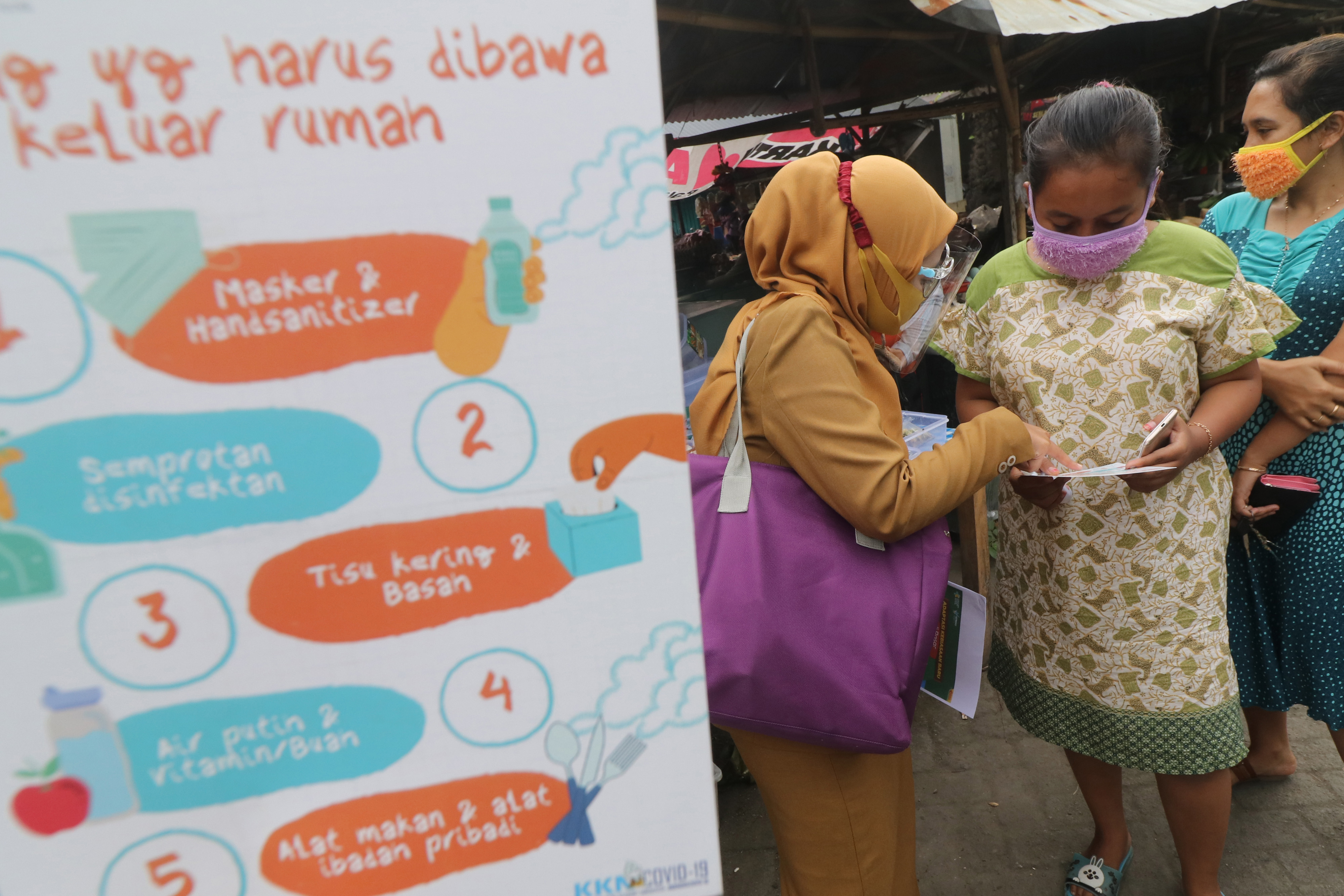 Petugas melakukan sosialisasi Adaptasi Kebiasaan Baru saat pandemi COVID-19 di pasar Sumberejo, Kediri, Jawa Timur, Selasa (21/7).