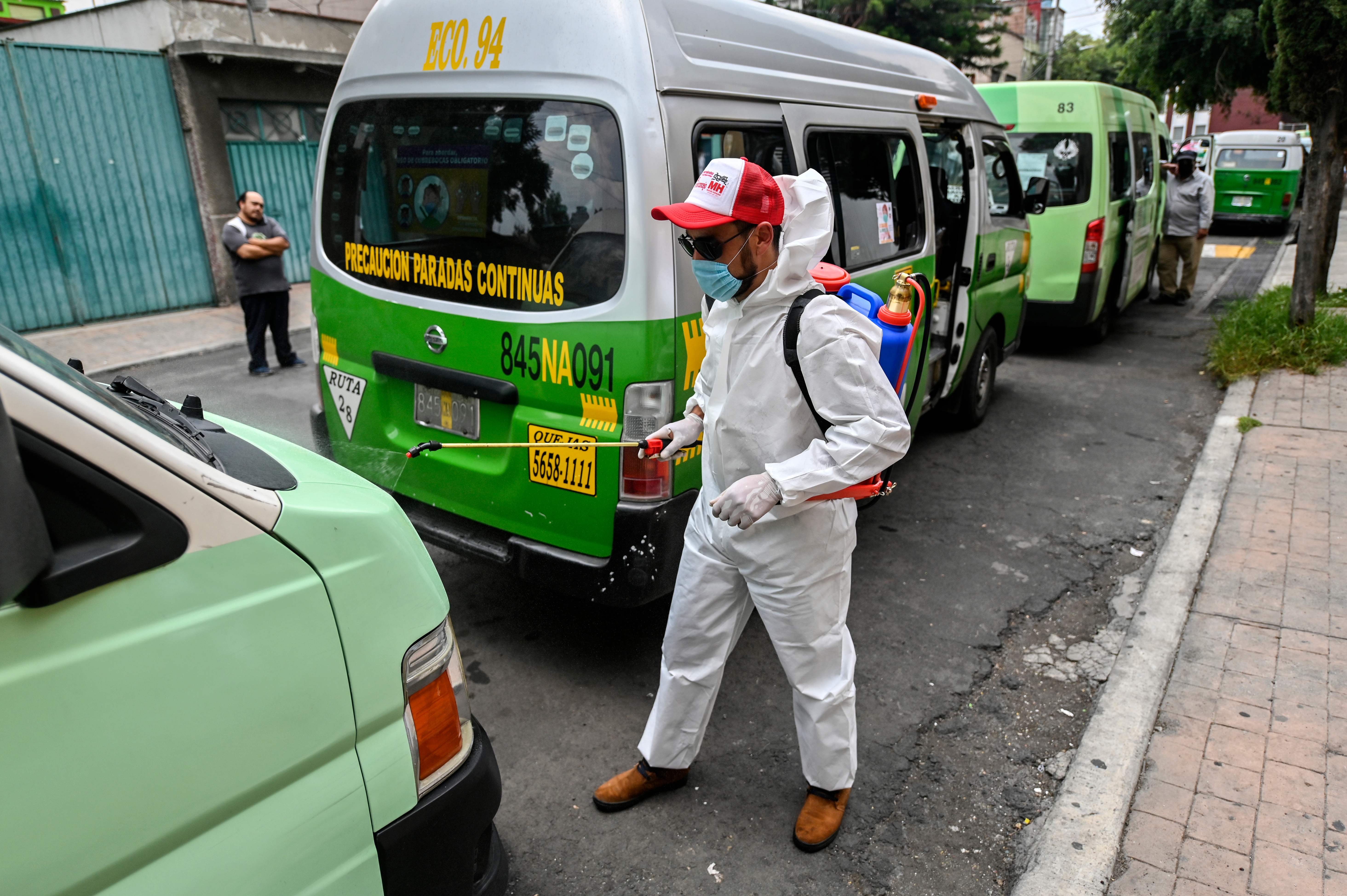 Petugas menyemprotkan disinfektan pada angkutan umum di Meksiko (30 Juli 2020)
