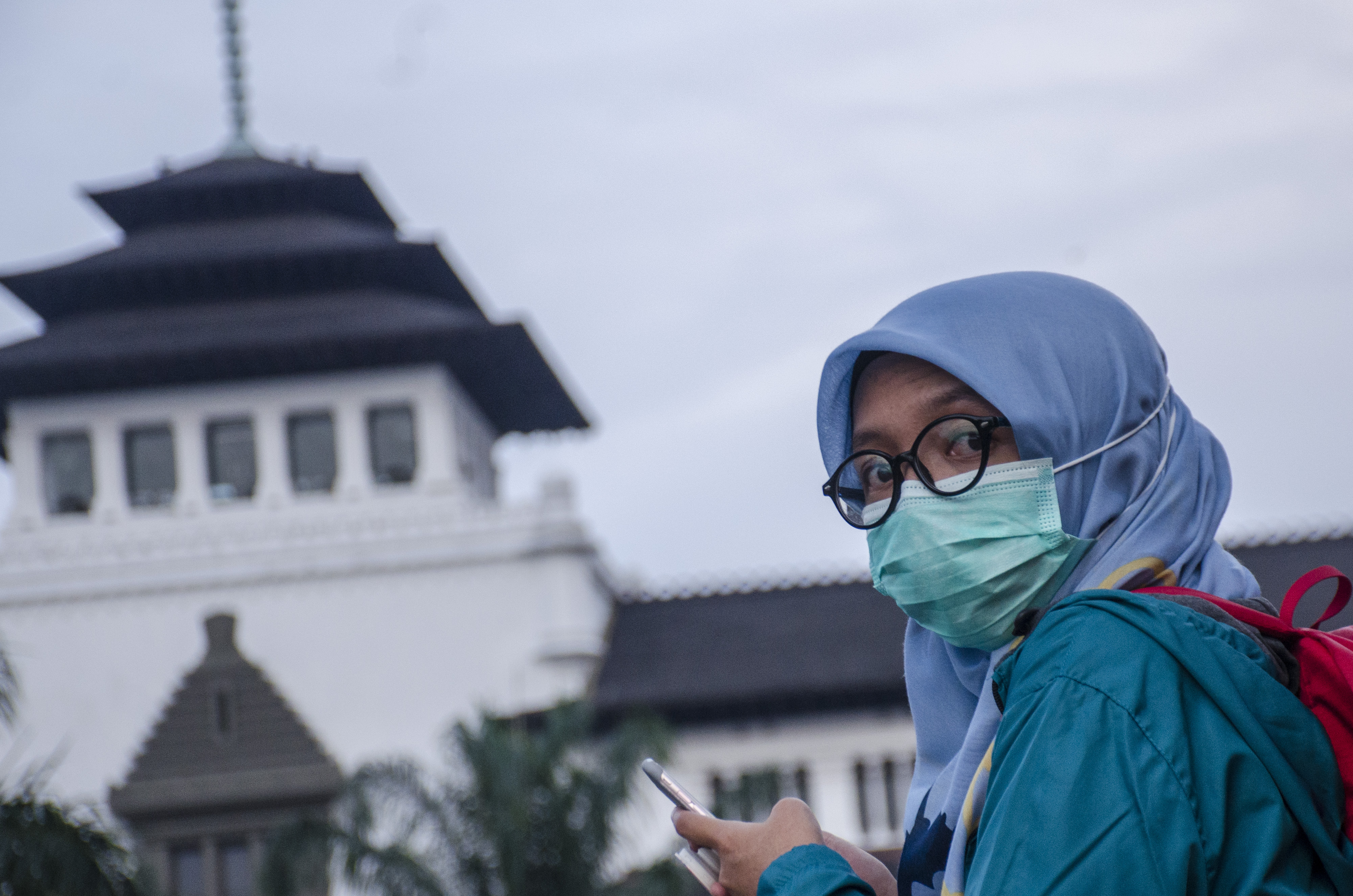 Warga mengenakan masker saat beraktivitas di depan Gedung Sate, Bandung, Jawa Barat.