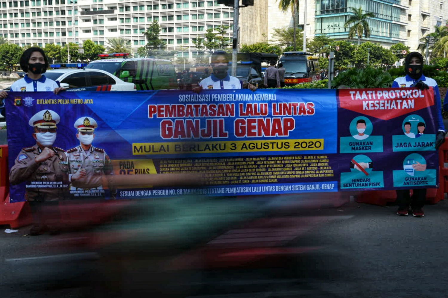 Anggota Kepolisian gelar sosialisasi pemberlakuan kembali ganjil genap di kawasan Bundaran HI, Jakarta Pusat, Minggu (2/8/2020).