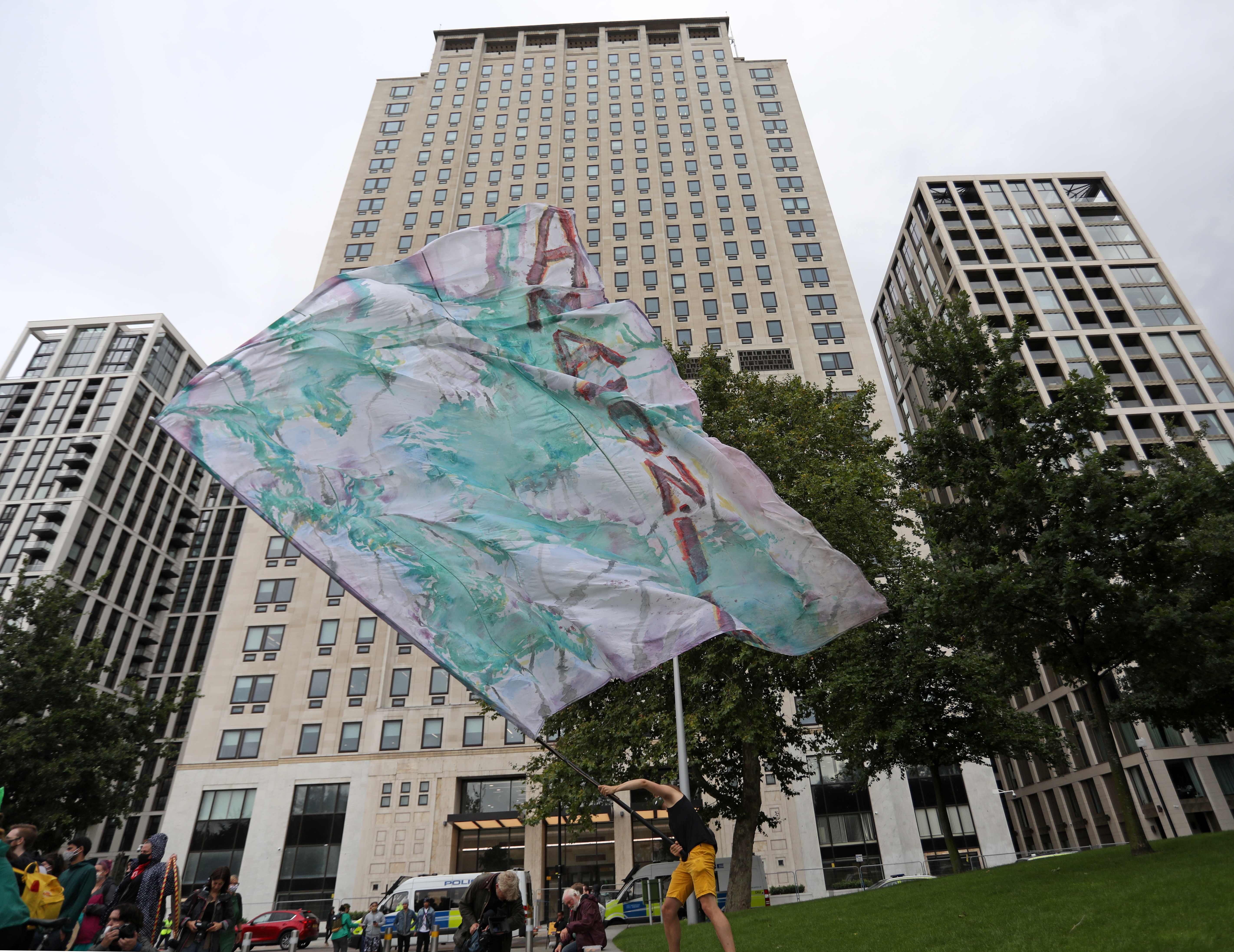 Aktivis lingkungan mengibarkan bendera protes di depan parlemen Brasil