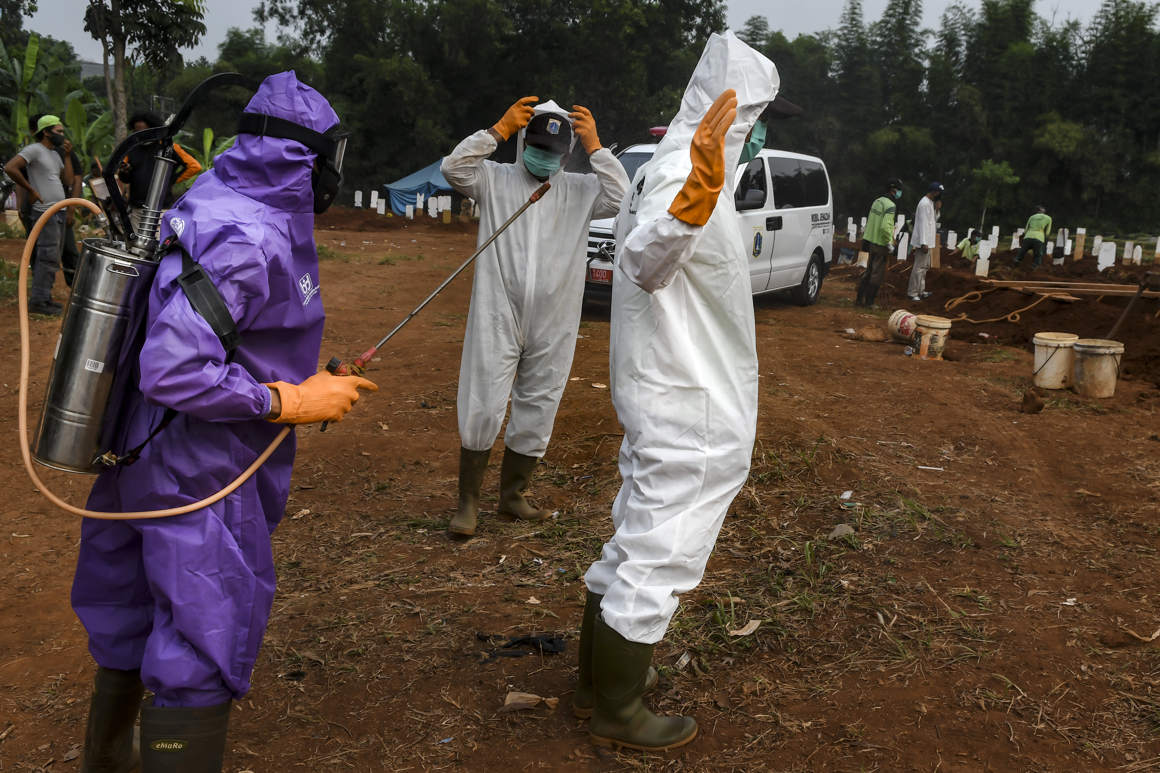Petugas melakukan penyemprotan cairan disinfektan usai memakamkan jenazah di TPU Pondok Ranggon, Jakarta, Jumat (10/7/2020).