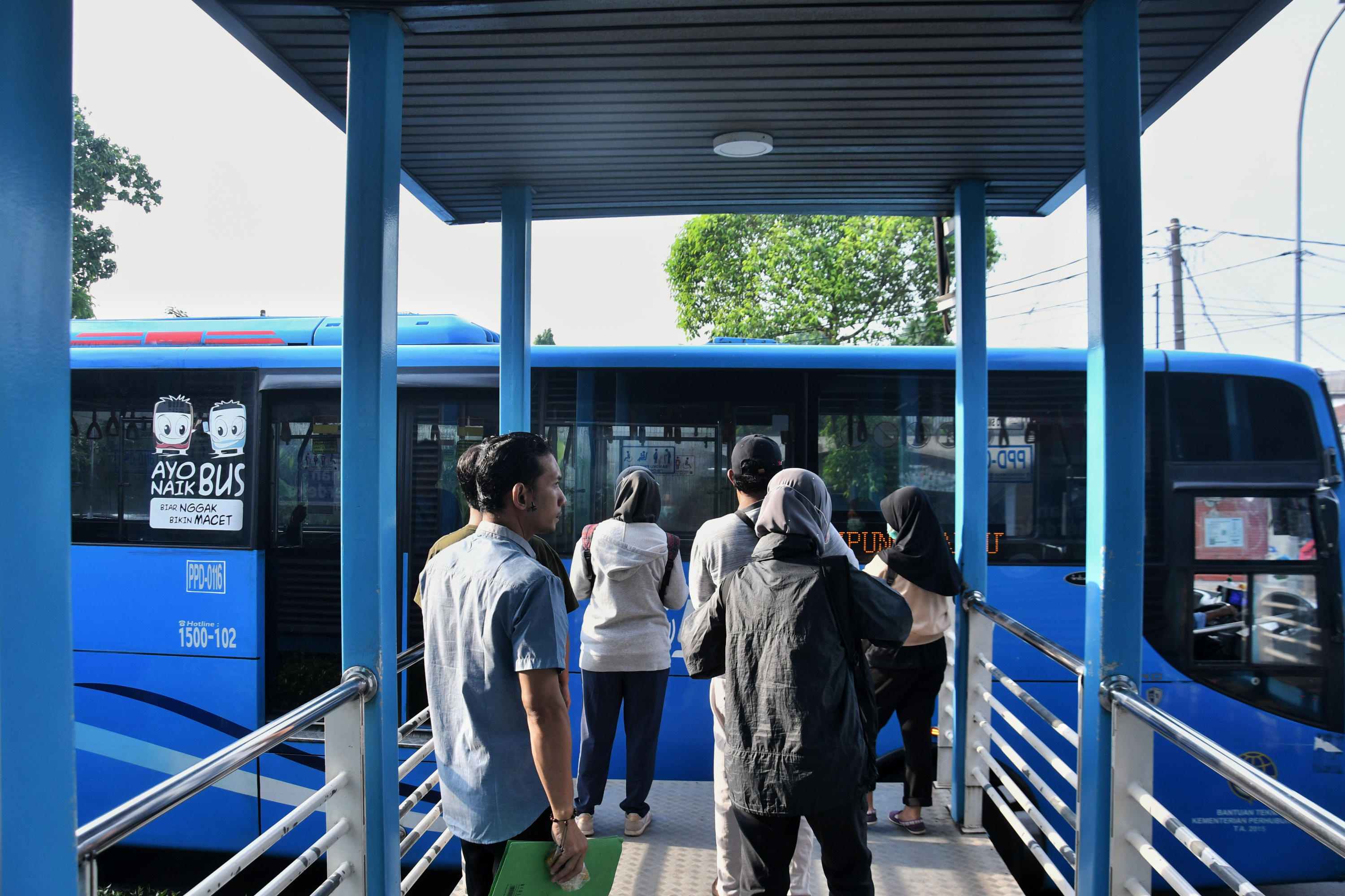 Calon penumpang menjaga jarak saat mengantri untuk menaiki bus Transjakarta di Jakarta, Kamis (19/3/3030).