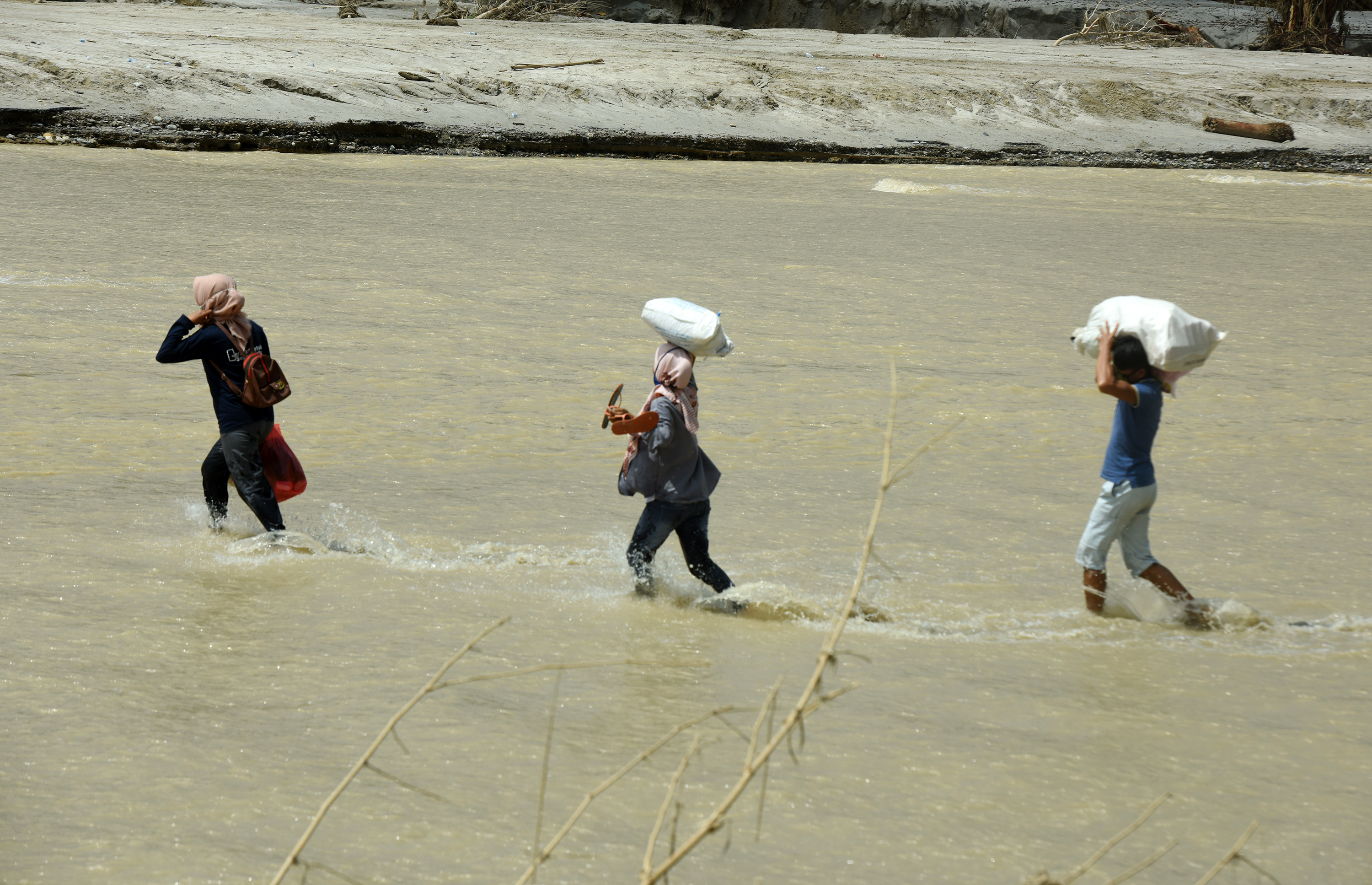 Warga menyeberangi sungai di Desa Petambua Masamba, kabupaten Luwu Utara, Sulawesi Selatan.