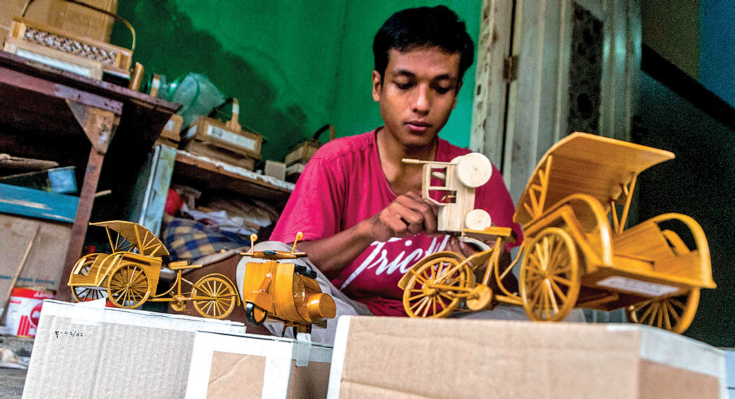 Pekerja menyelesaikan produksi miniatur dari bambu di Desa Cimangeunteung, Lebak, Banten.