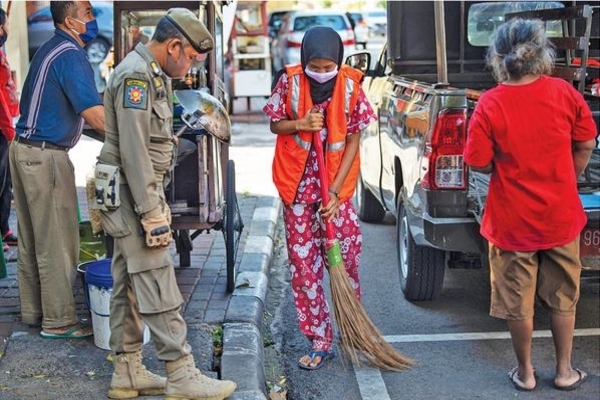 Petugas Satpol PP memberi sanksi terhadap pelanggar aturan protokol kesehatan covid-19 selama masa PSBB transisi di kawasan Juanda, Jakarta,