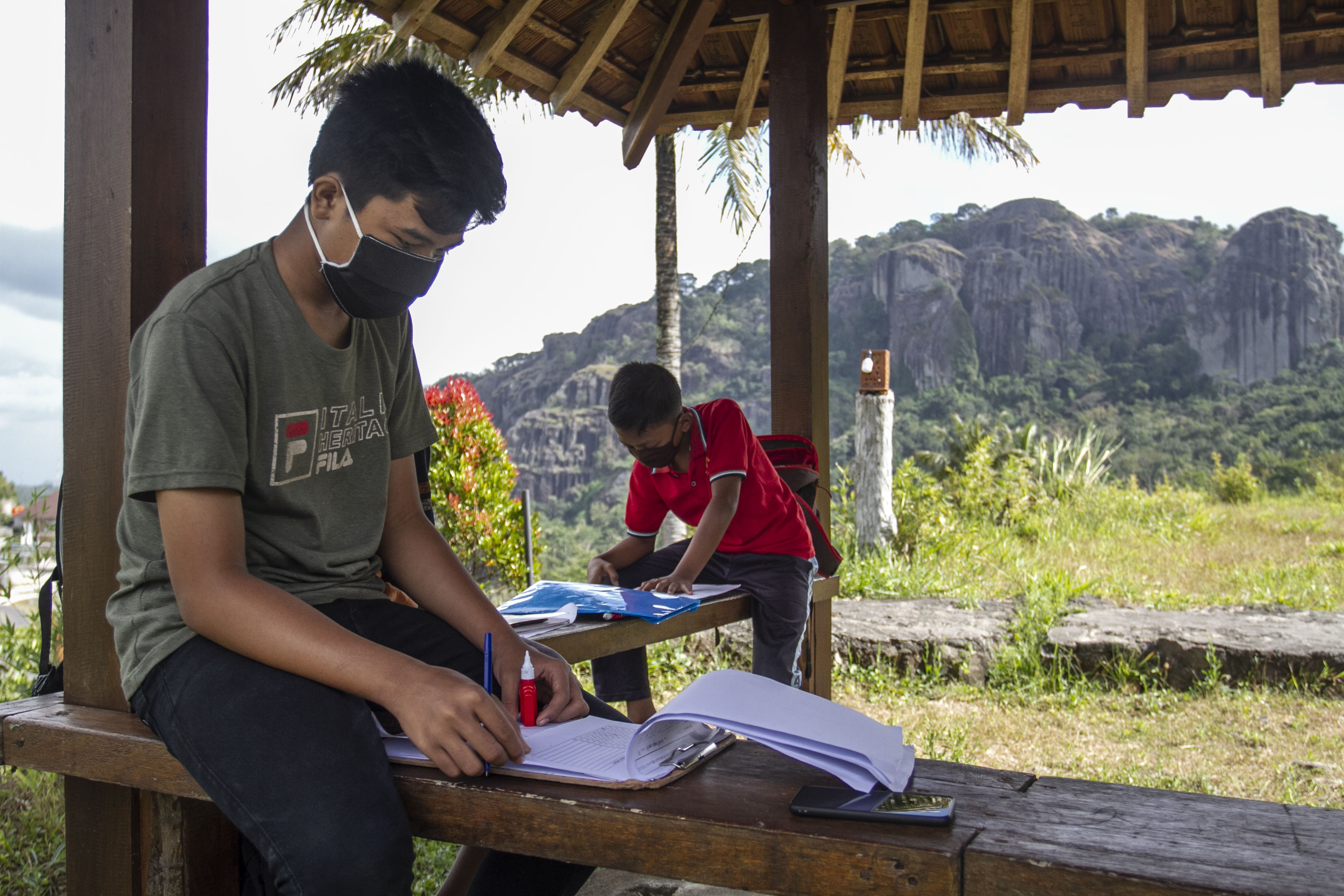 Siswa SMP 4 Patuk mengerjakan tugas sekolah memanfaatkan jaringan internet publik di kawasan wisata Embung Nglanggeran, Patuk, Gunungkidul.