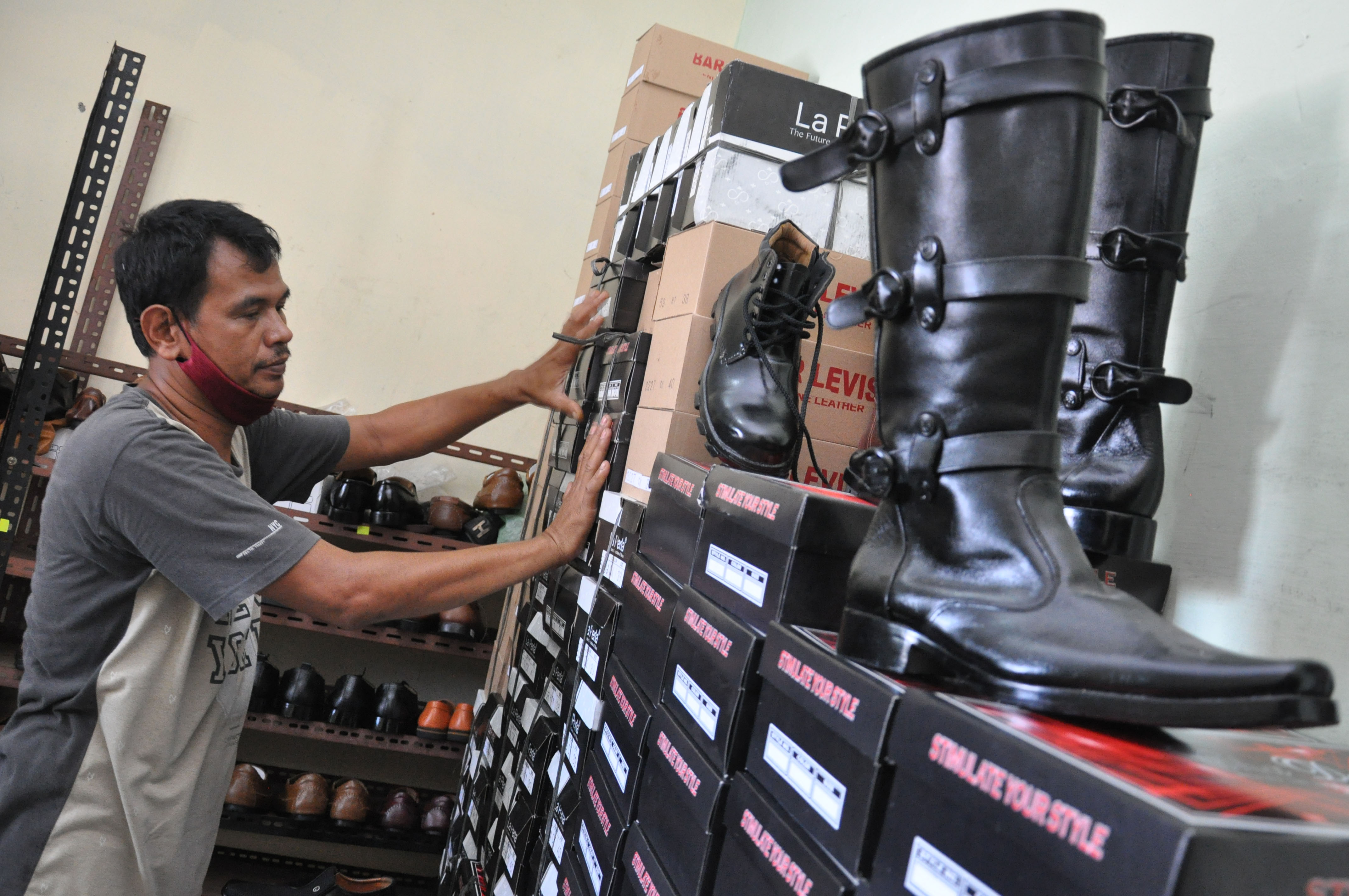 Seorang perajin sepatu menyusun produk sepatu buatannya yang dijual Rp100 ribu hingga Rp600 ribu per pasang (tergantung model)