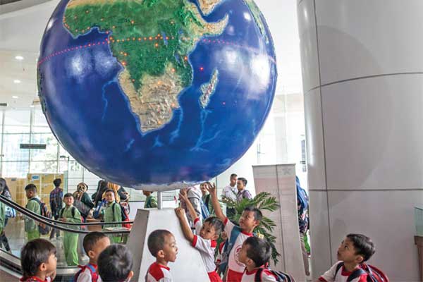 Pelajar mengamati globe di Perpustakaan Nasional, Jakarta