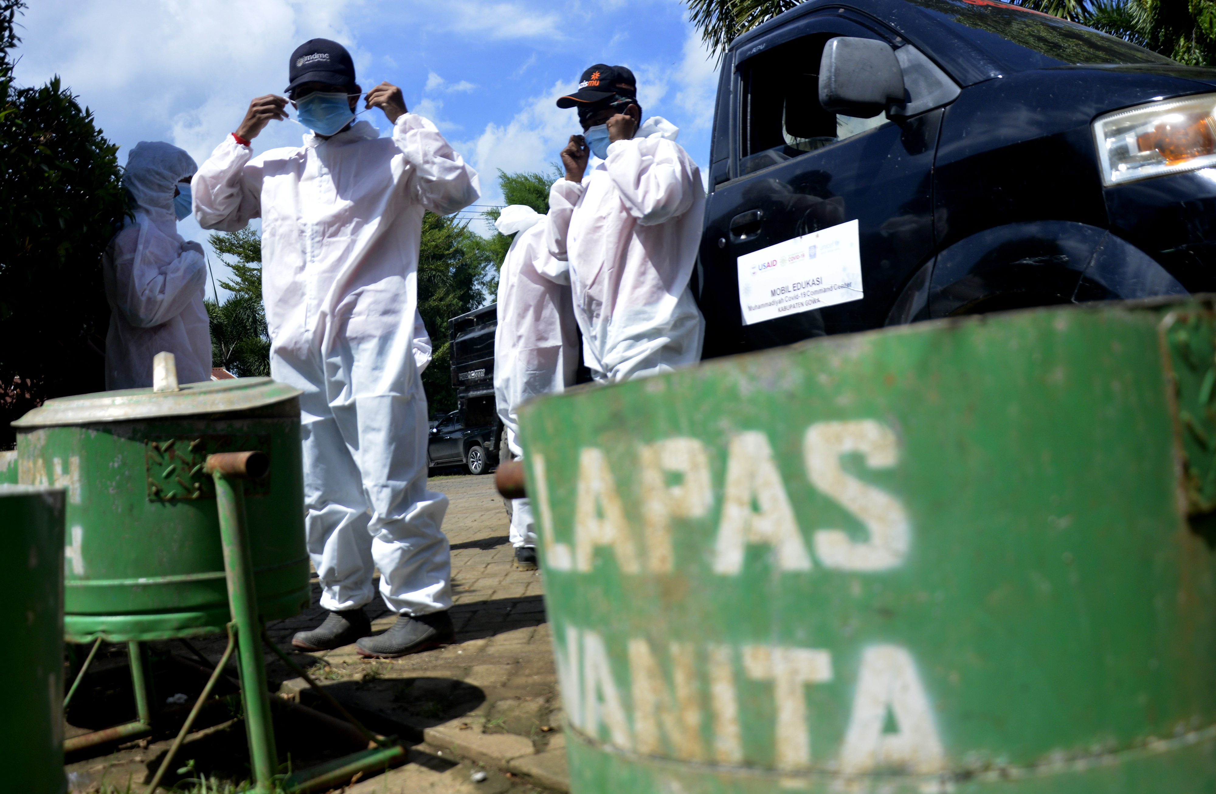 Petugas memakai baju hazmat memasuki area lembaga pemasyarakatan. 