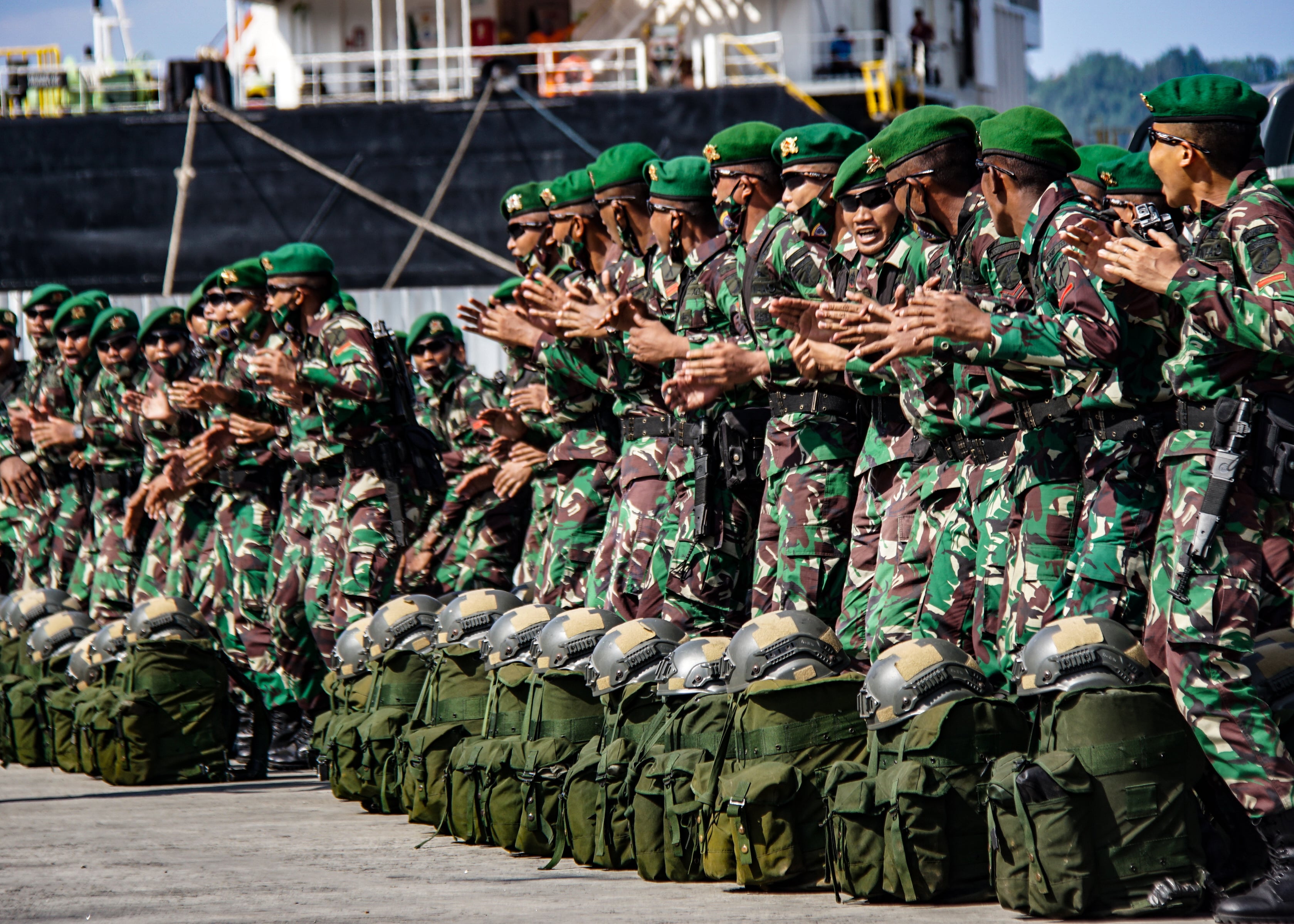Prajurit Satgas Pamtas RI menyanyikan lagu daerah asal Papua sebelum naik ke KRI Banjarmasin 592 yang sandar di Pelabuhan Jayapura, Papua.