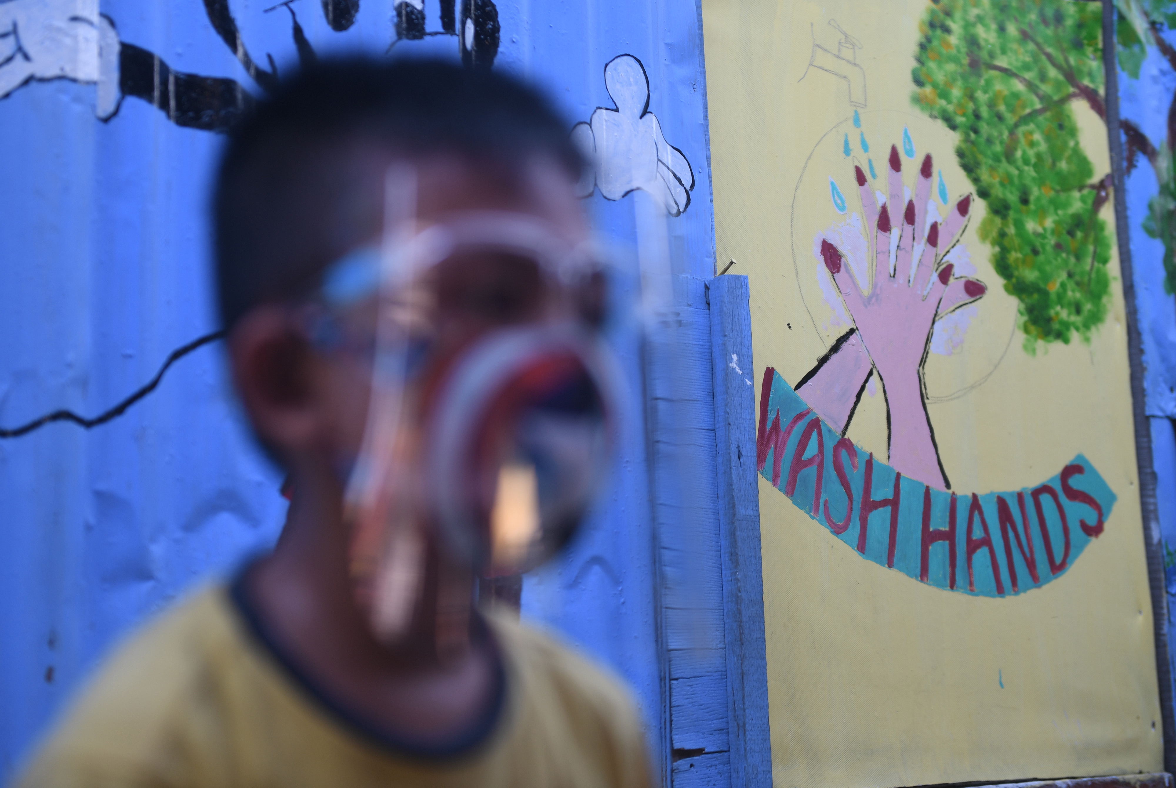 Seorang anak melintasi mural bertema COVID-19 di Jakarta, Senin (27/7).