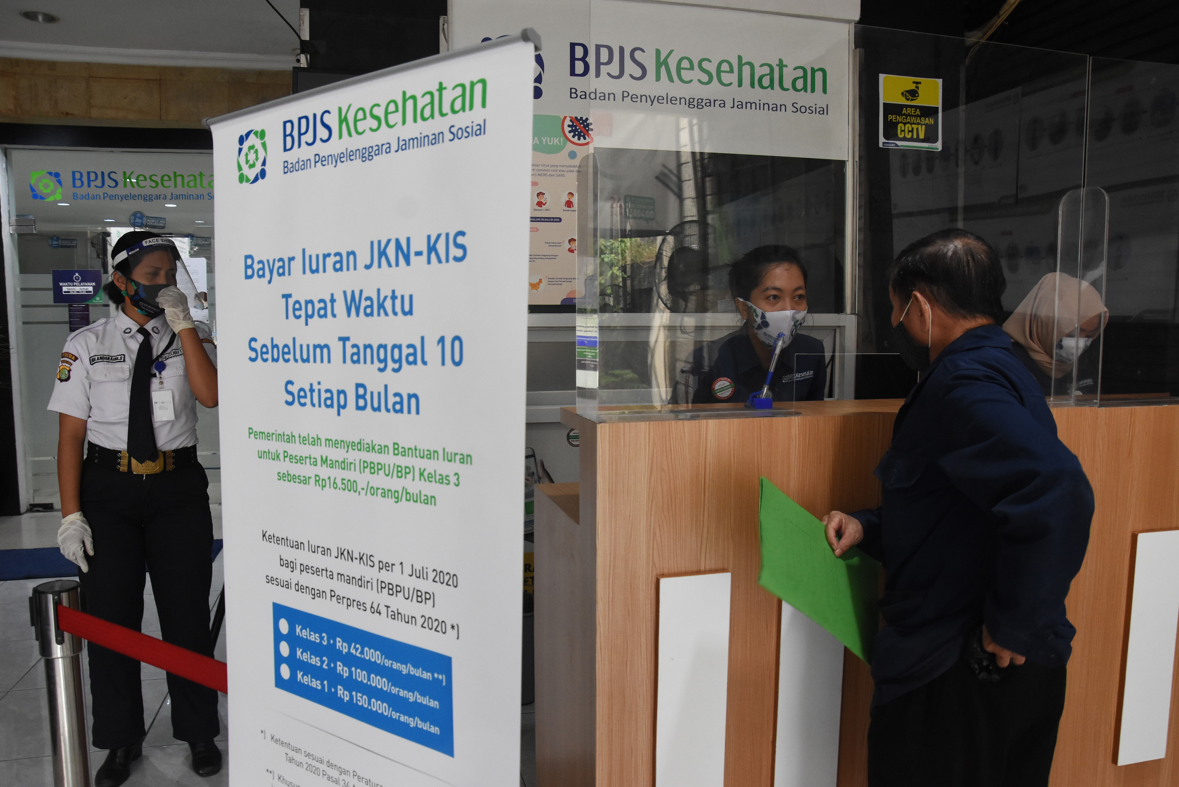 ekat pembatas dipasang di antara petugas dan peserta BPJS Kesehatan saat pelayanan di Kantor BPJS Kesehatan Cabang Jakarta Pusat.