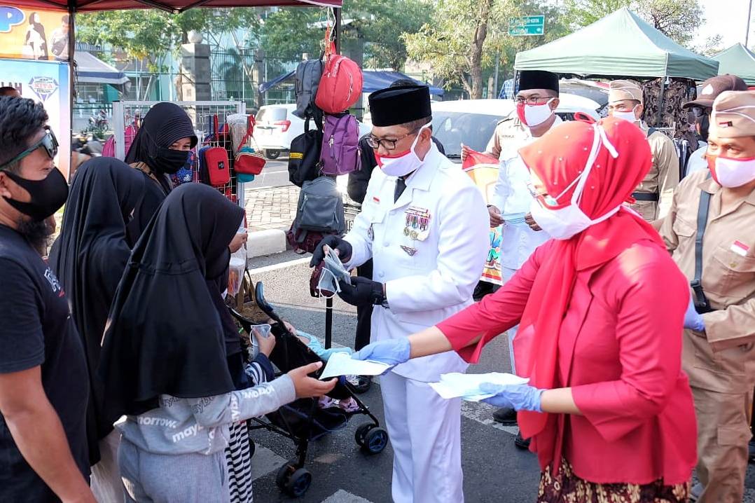 Kapolresta Sidoarjo Kombes Sumardji (jas putih) membagikan masker.