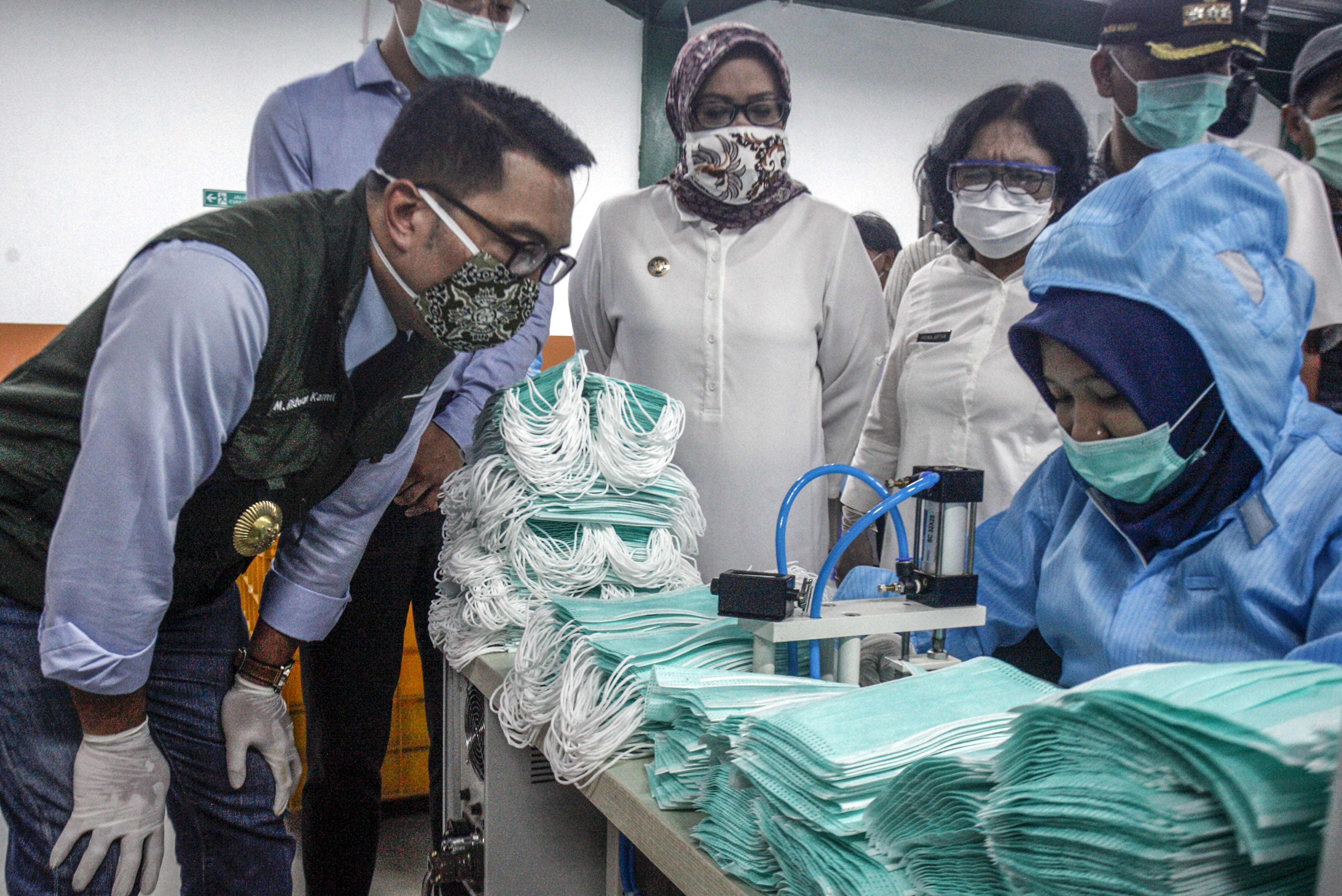 Gubernur Jawa Barat Ridwan Kamil (kiri) melihat pembuatan masker medis di PT Multi One Plus, Gunung Putri, Bogor, Jawa Barat, Rabu (15/4)